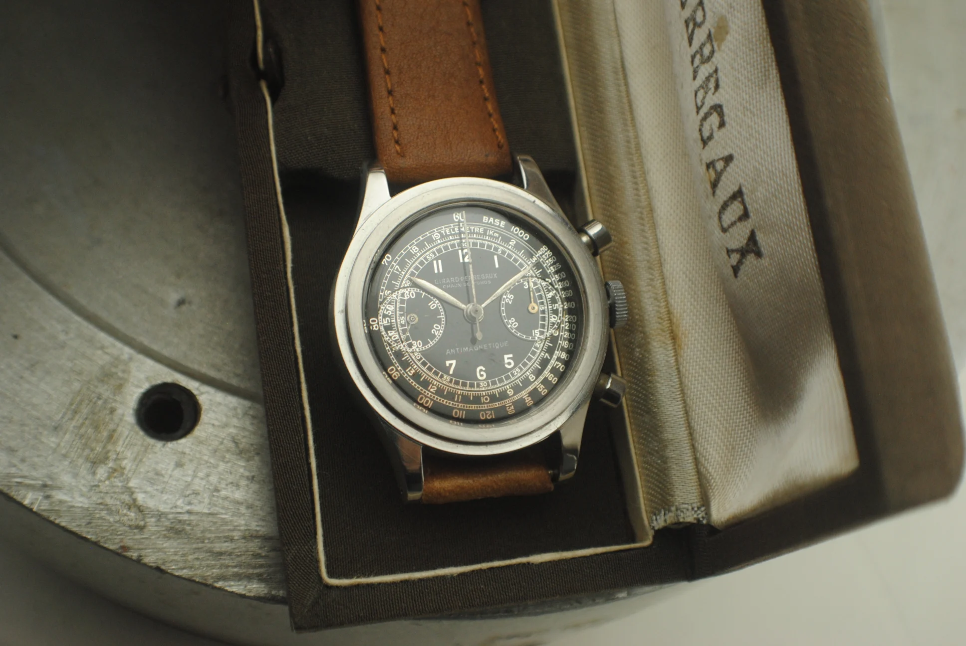 Front view of the Girard-Perregaux stepcase chronograph resting in its fitted period box