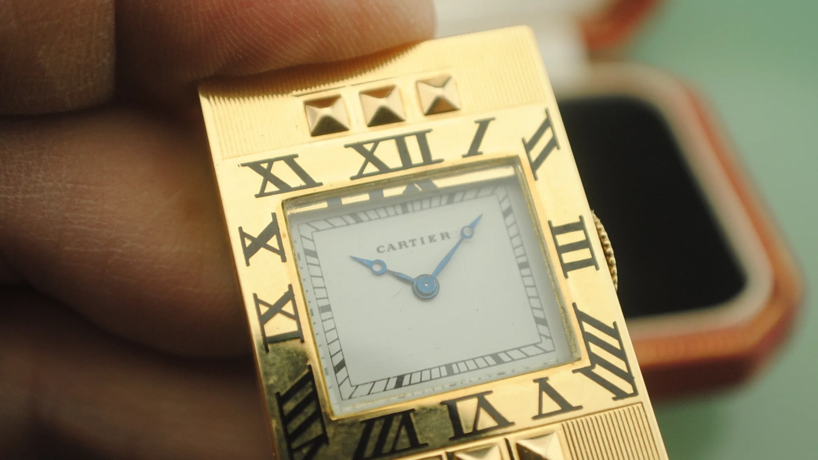 Clean close view of the Cartier Guillotine opened to reveal its signed white dial and blued hands