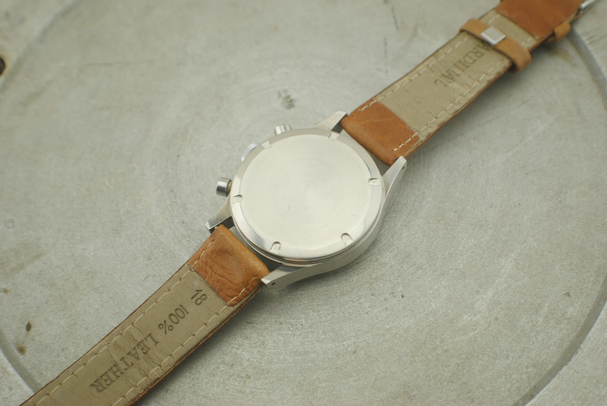 Exterior screw-down caseback of the Girard-Perregaux stainless-steel chronograph and brown leather strap