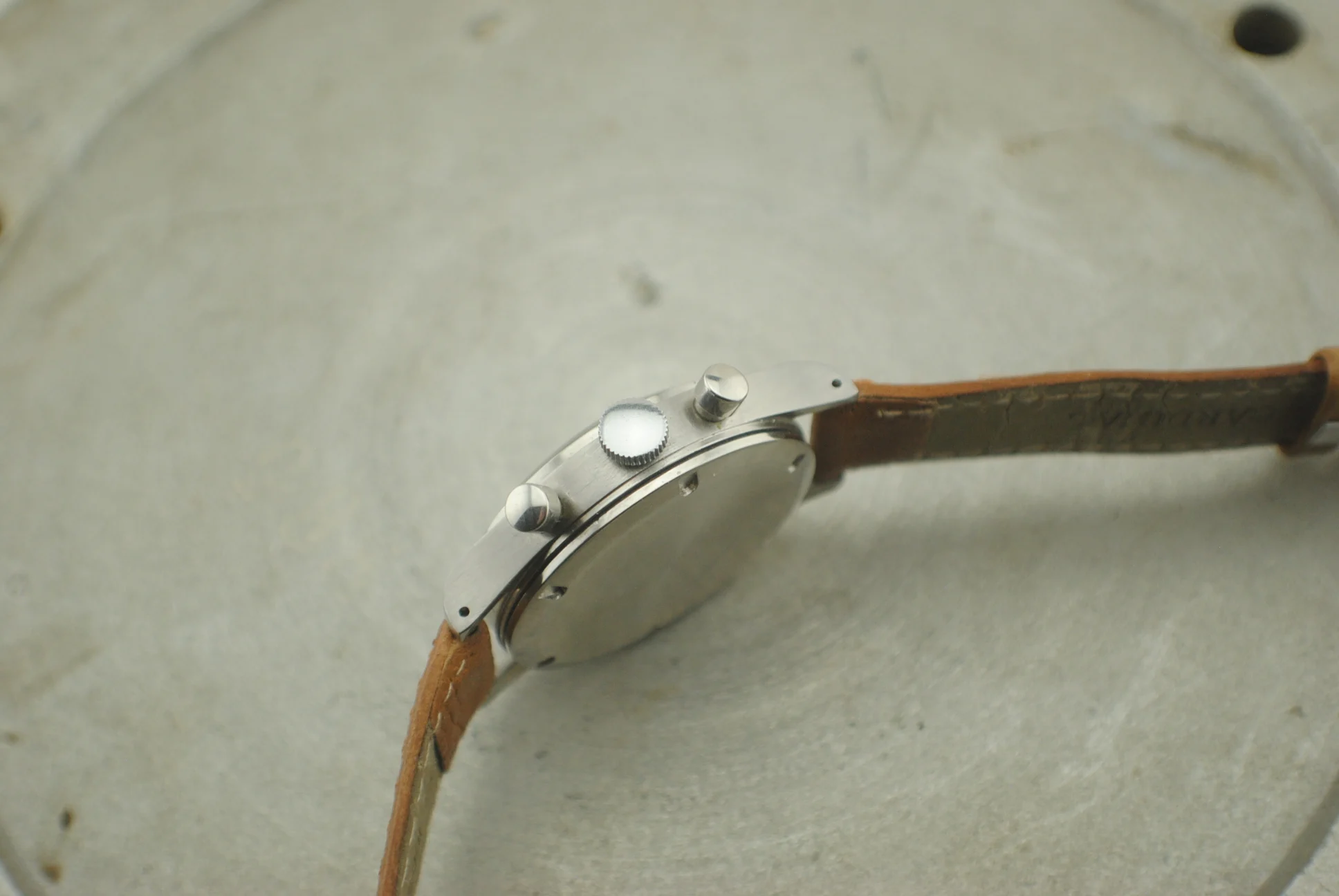 Crown-side profile of the Girard-Perregaux stepped stainless-steel case with round chronograph pushers