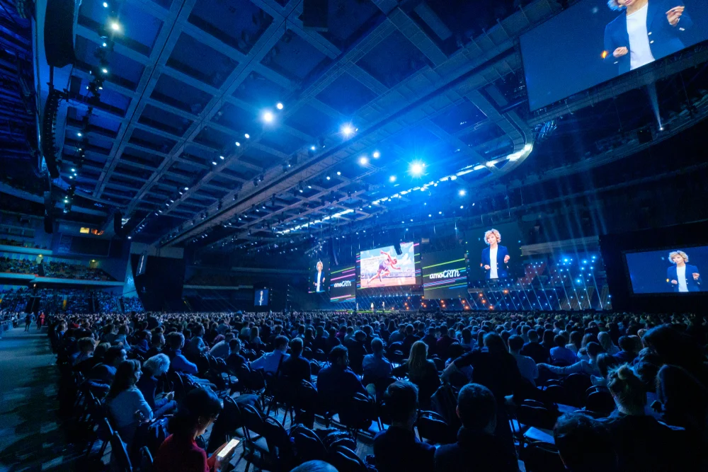 SPYEX speaker on stage in front of a large conference audience