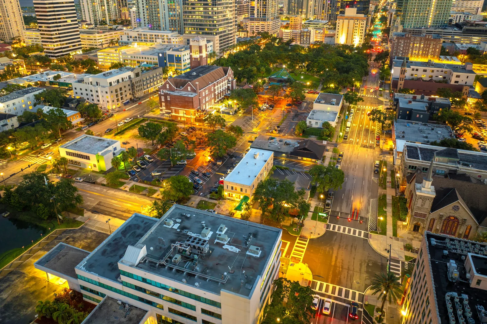 Illuminated city streets and buildings seen from above at dusk