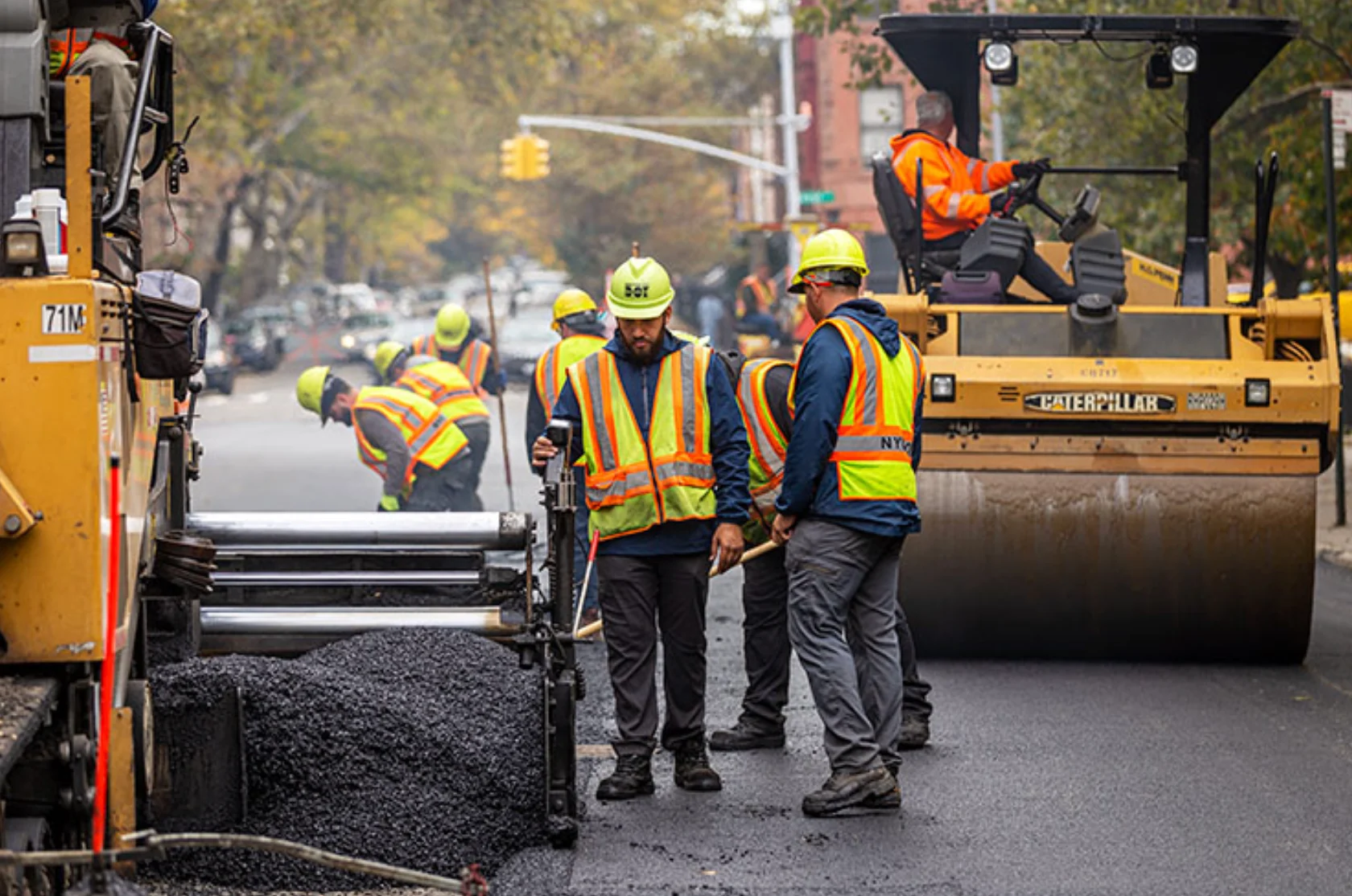 NYC DOT paving crews placing and compacting asphalt on a New York City street