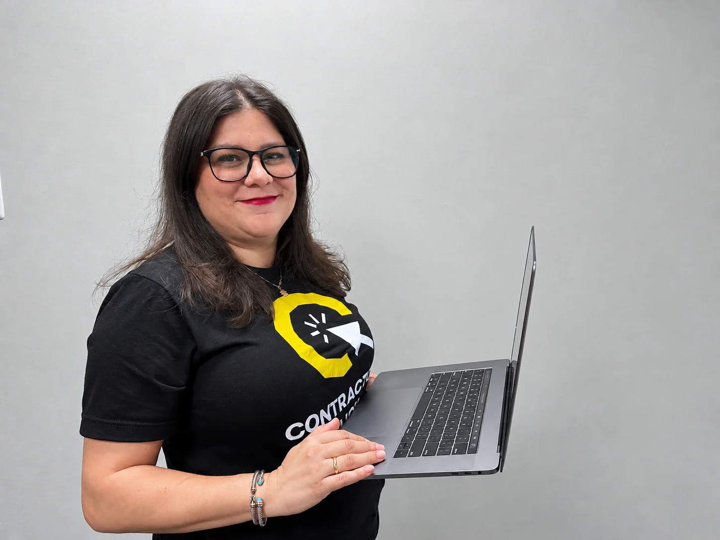 Mady Barrera of Contractor Click holding an open laptop