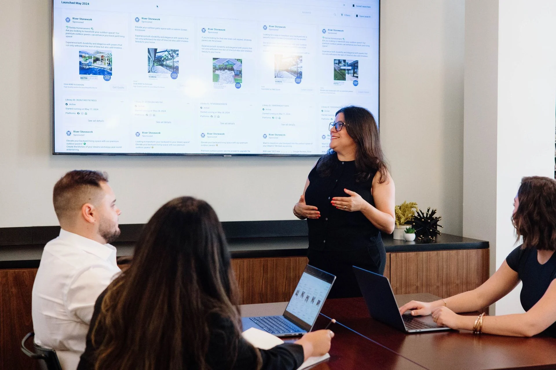 A Contractor Click team member teaches colleagues using live ad campaigns on a large screen