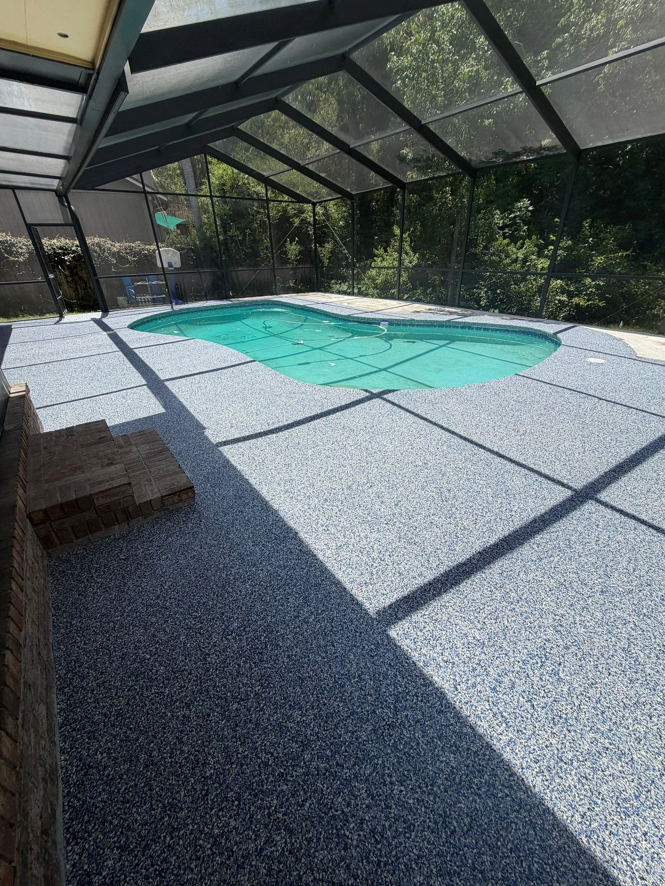 Finished blue and grey flake coating around a screened pool