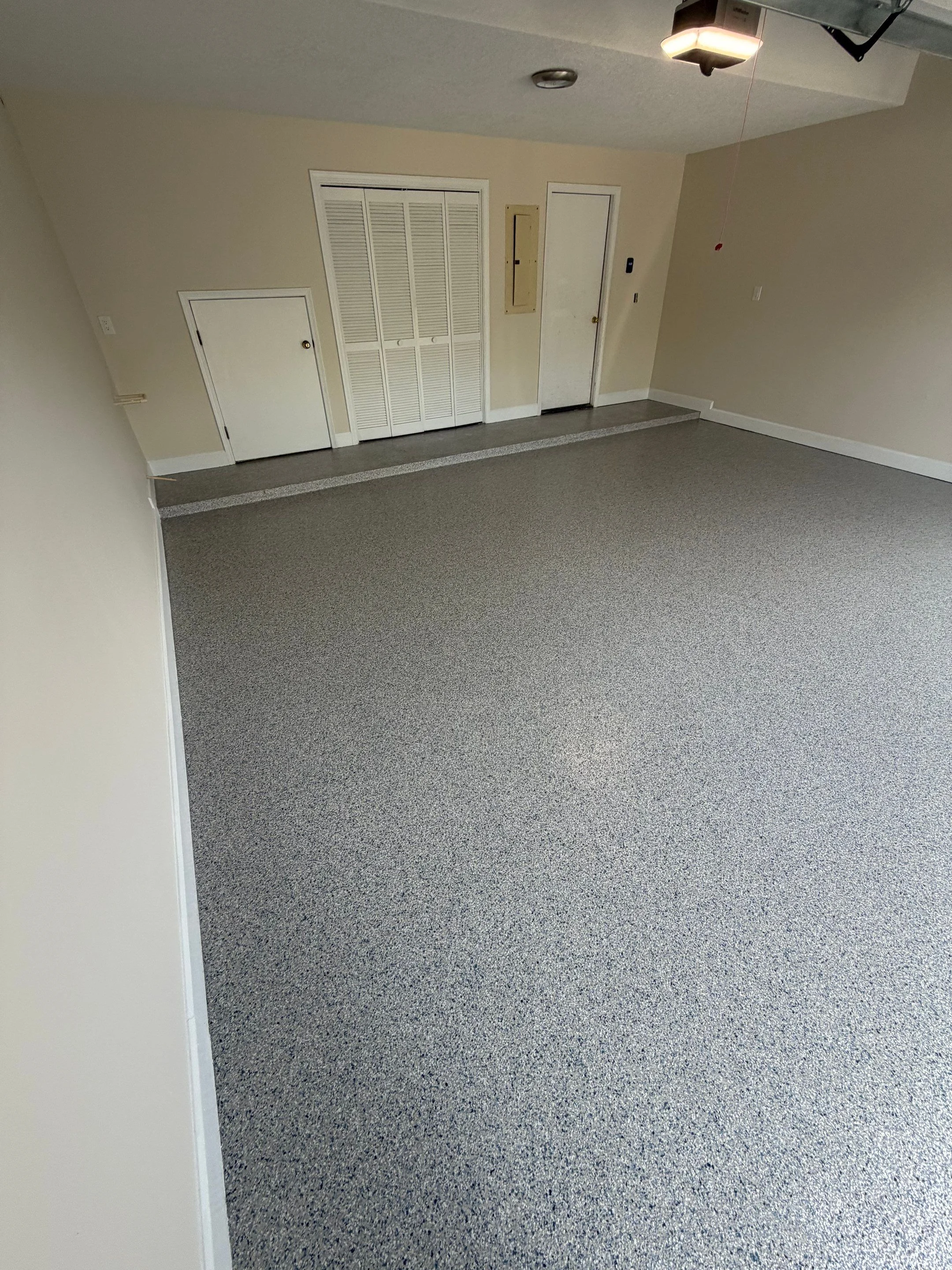 Finished light grey flake coating in a clean residential garage