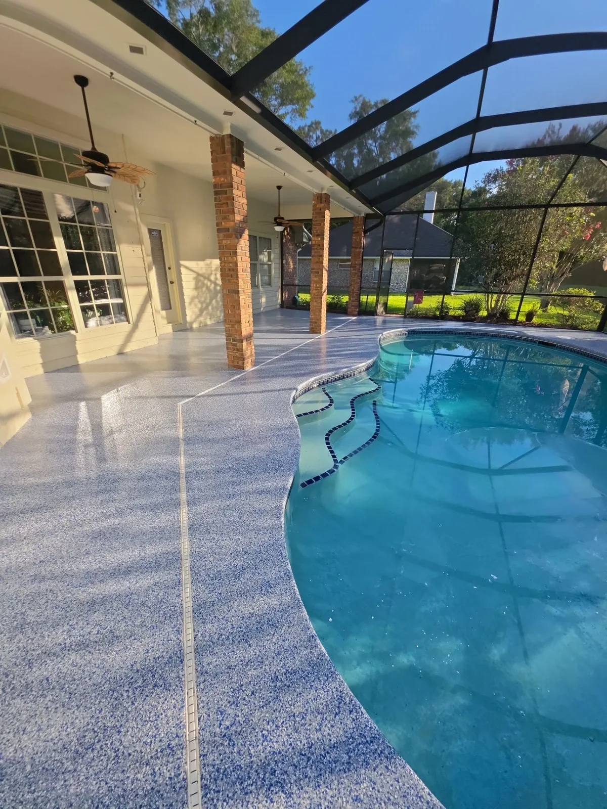 Finished blue flake coating around a curved residential pool