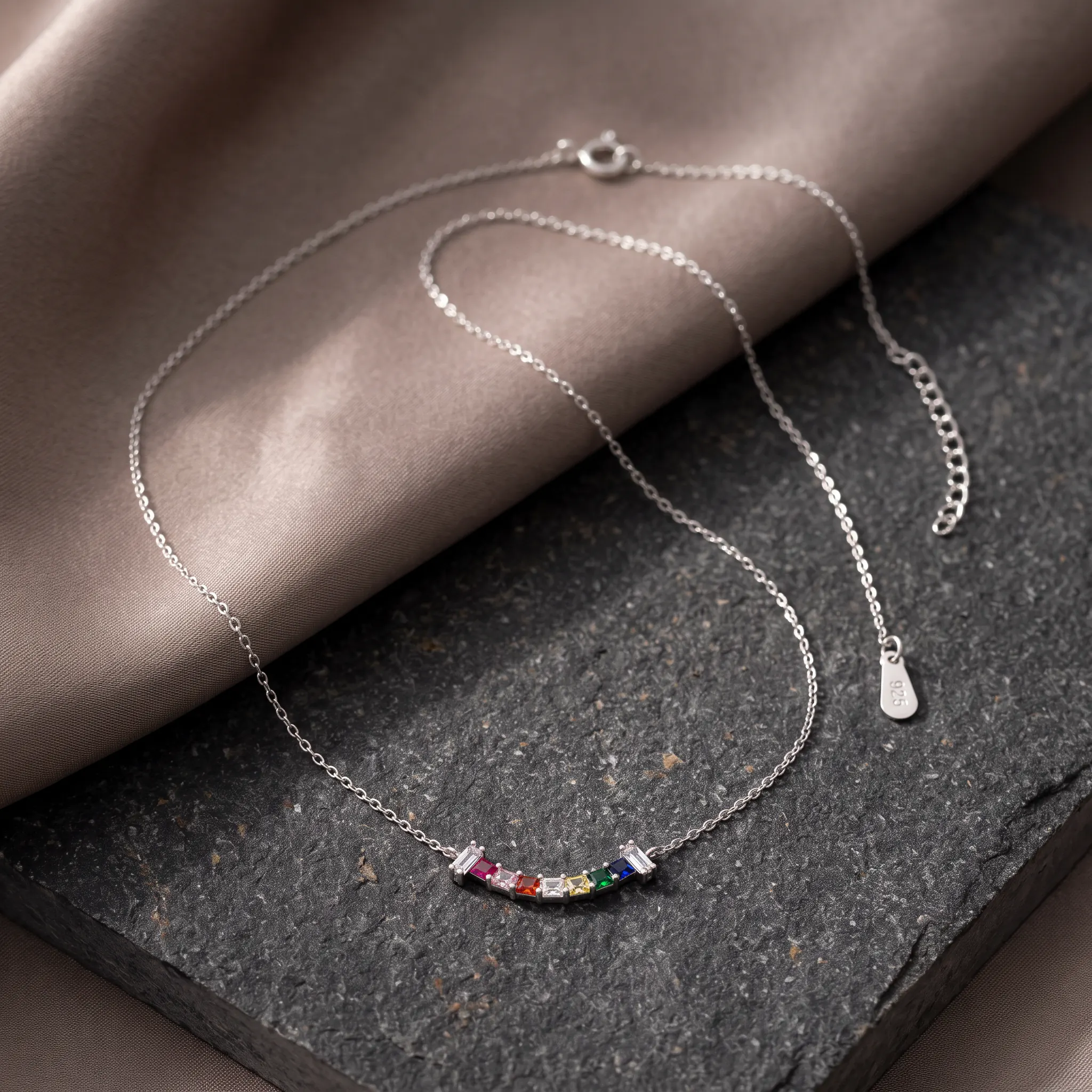 CHOODO InnerLight 925 sterling silver rainbow zircon pendant on charcoal stone and taupe fabric