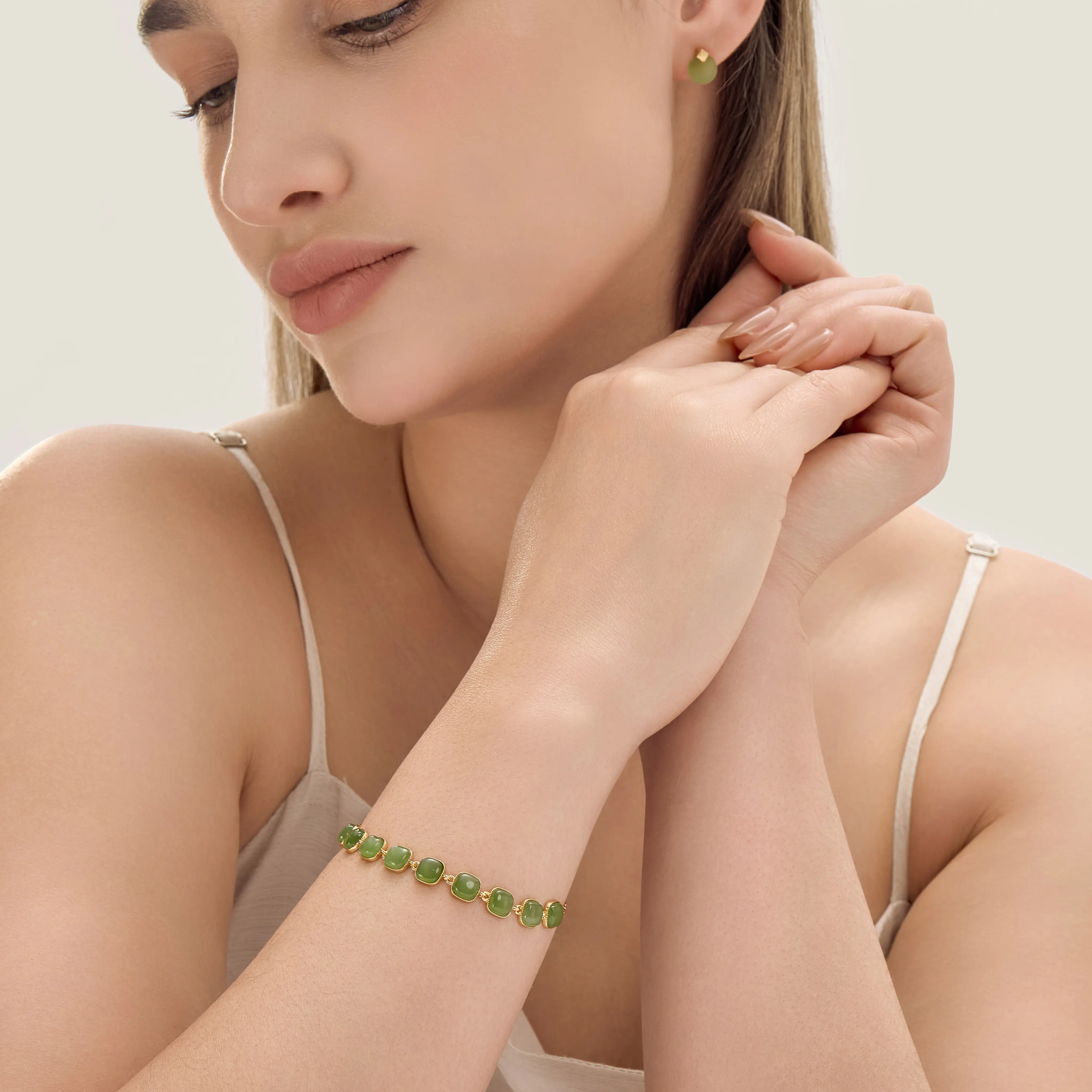 Woman wearing a green jade bracelet and matching earrings