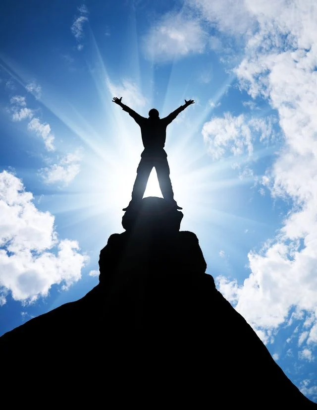 Person celebrating on a mountain summit