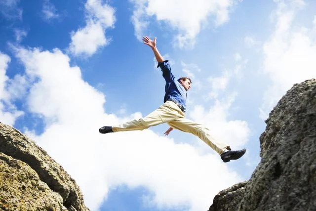 Person leaping between rocks