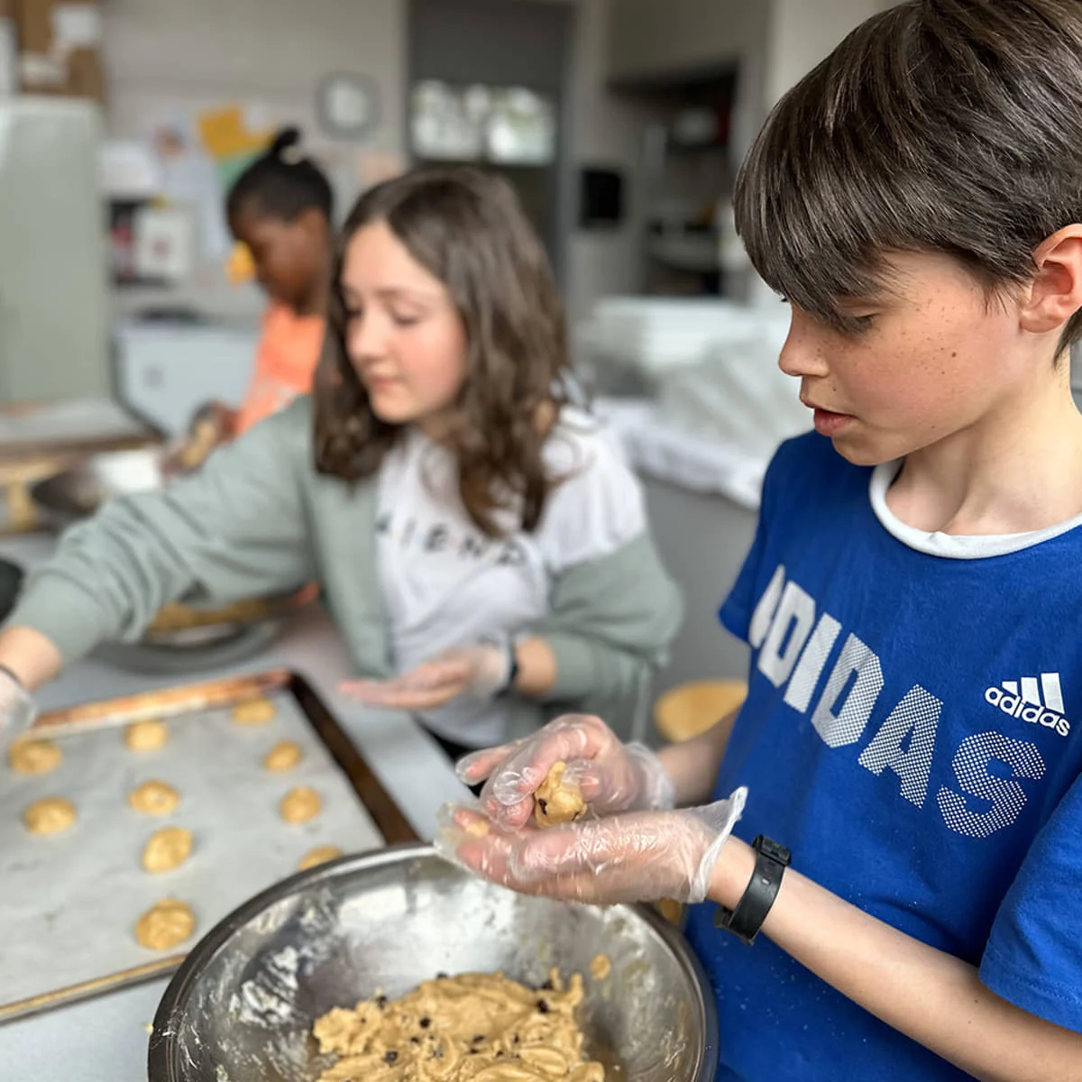 Élèves d'un Club Enfant K qui préparent des biscuits pour une levée de fonds