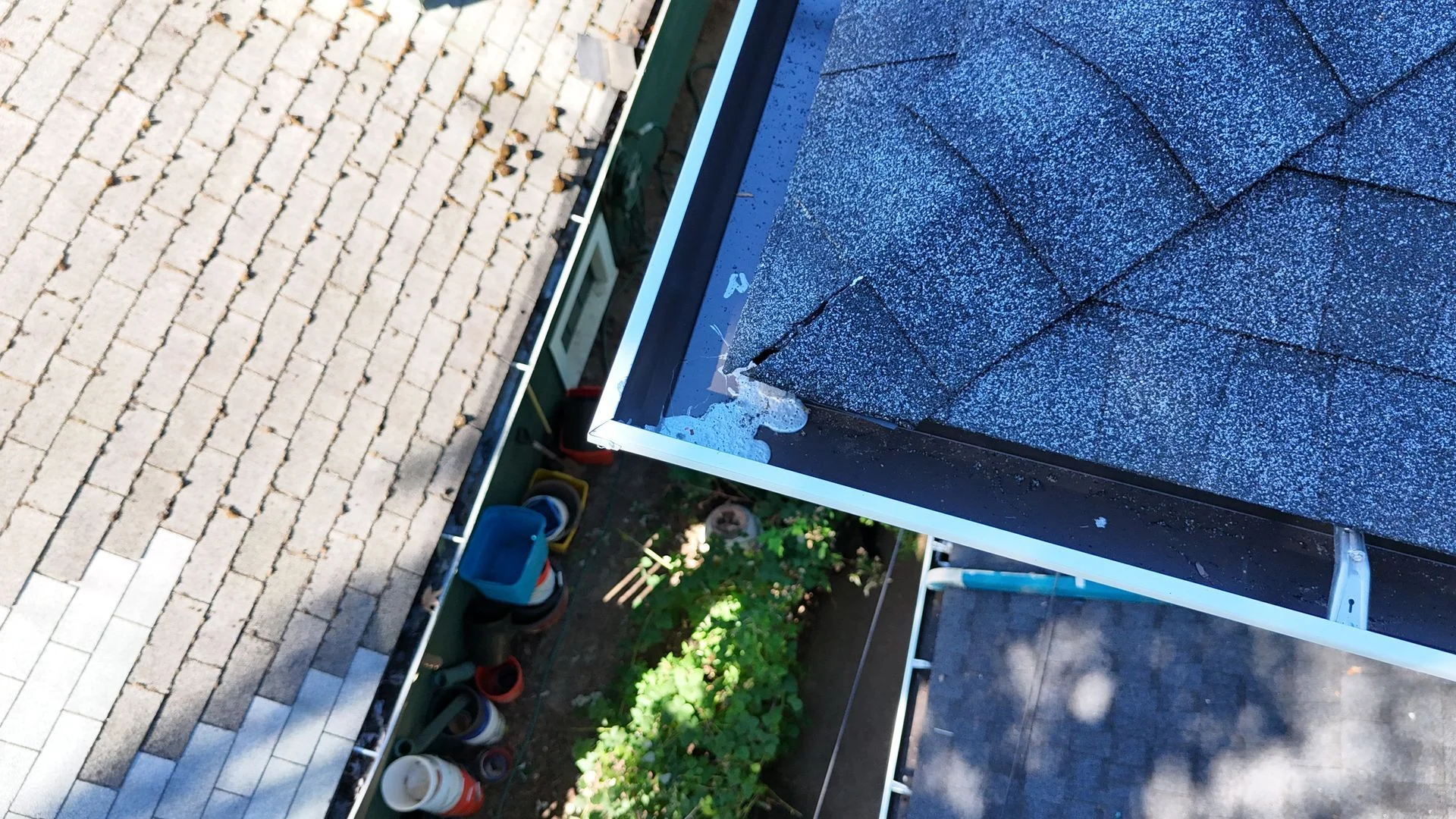 Close view of a white gutter and roof edge with sealant at the corner