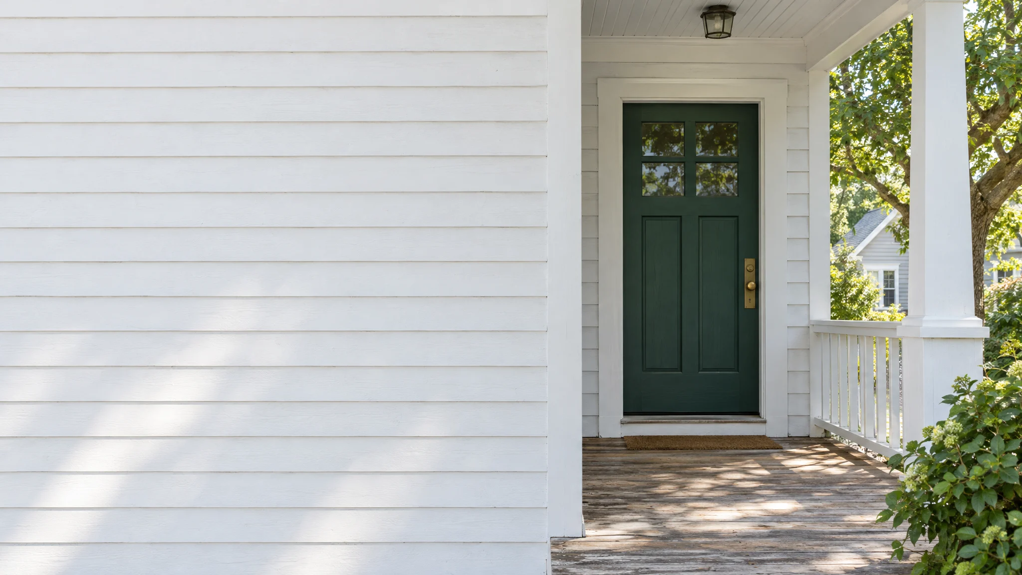 Sunlit Virginia porch with a green front door. Illustrative image.