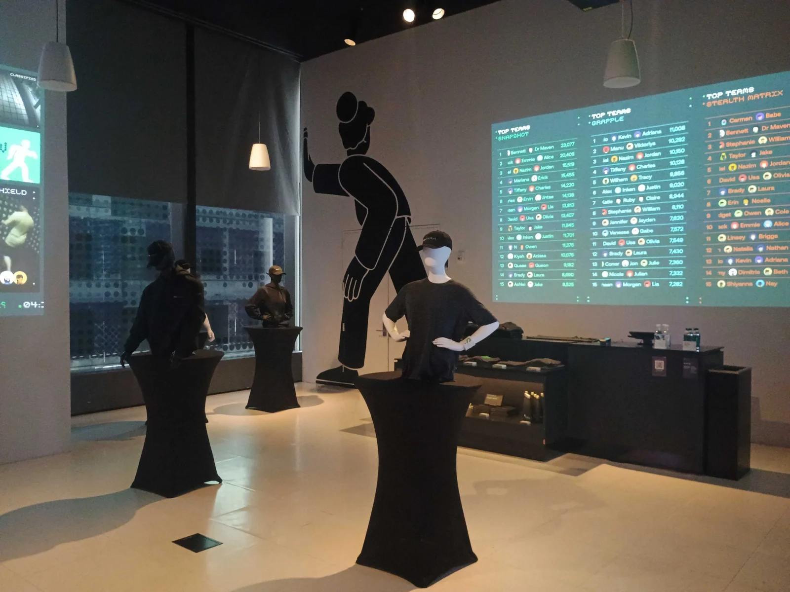 SPYGAMES reception area with cocktail tables and projected game leaderboards