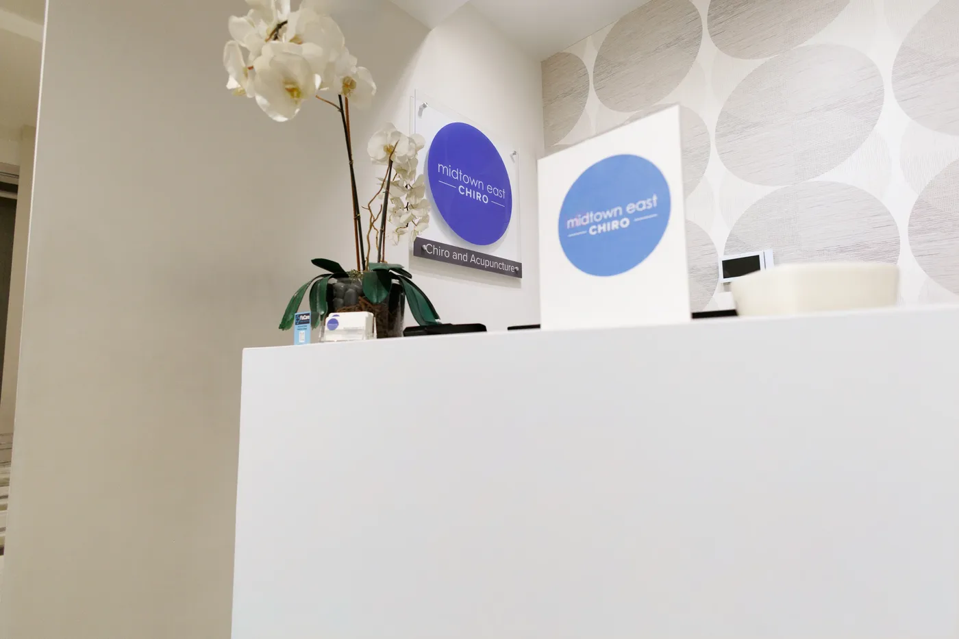 Front desk at Midtown East Chiropractic with the Midtown East Chiro logo sign