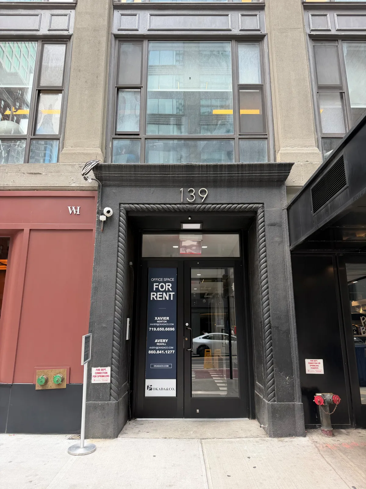 Street entrance of 139 East 57th Street, a dark stone doorway with the number 139 above glass doors