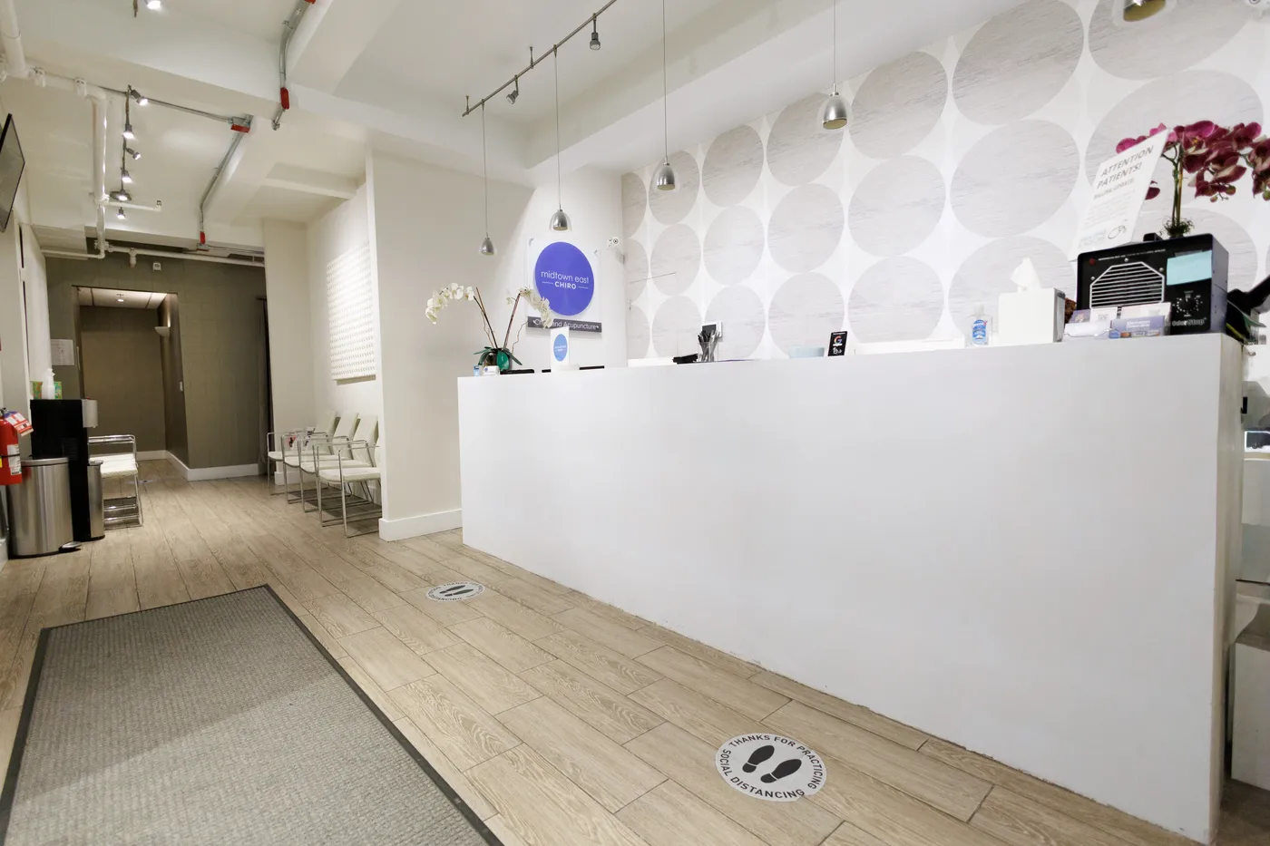 Midtown East Chiropractic reception desk and waiting area, with the blue Midtown East Chiro logo on the wall