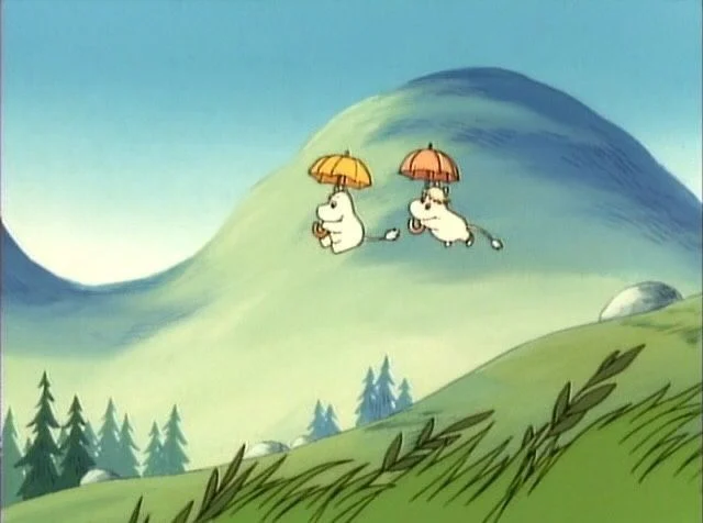 Moomin characters floating with umbrellas over a green mountain