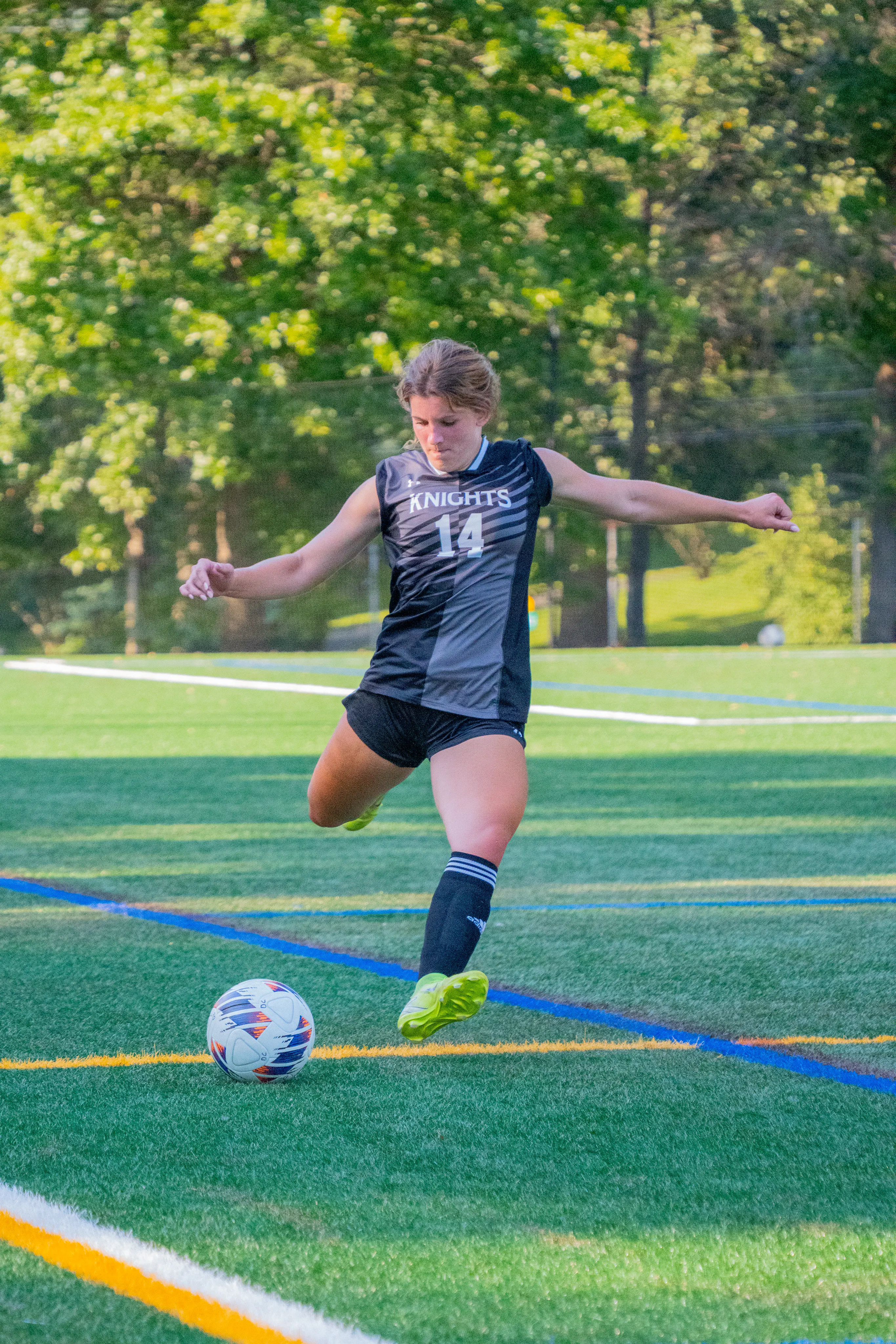 Soccer player number 14 preparing to kick the ball