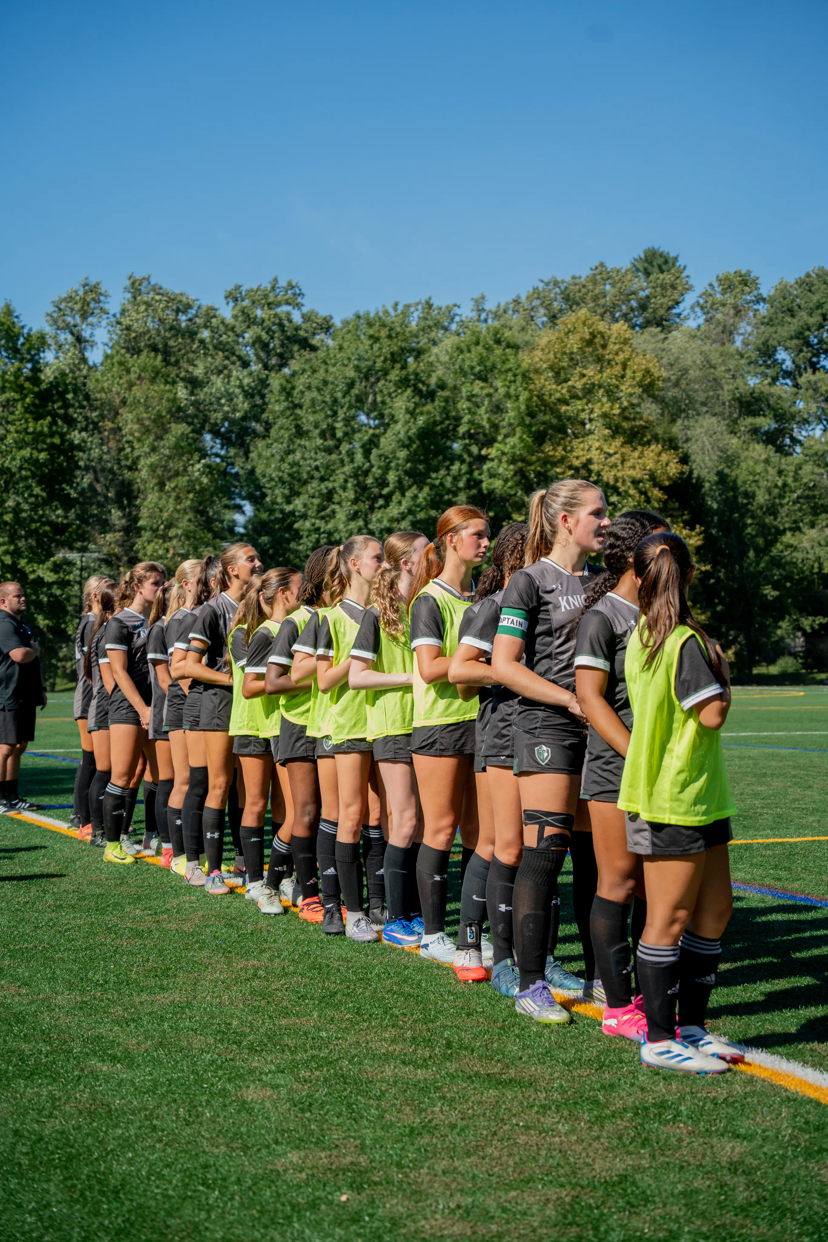 Soccer players lined up along the sideline before a match
