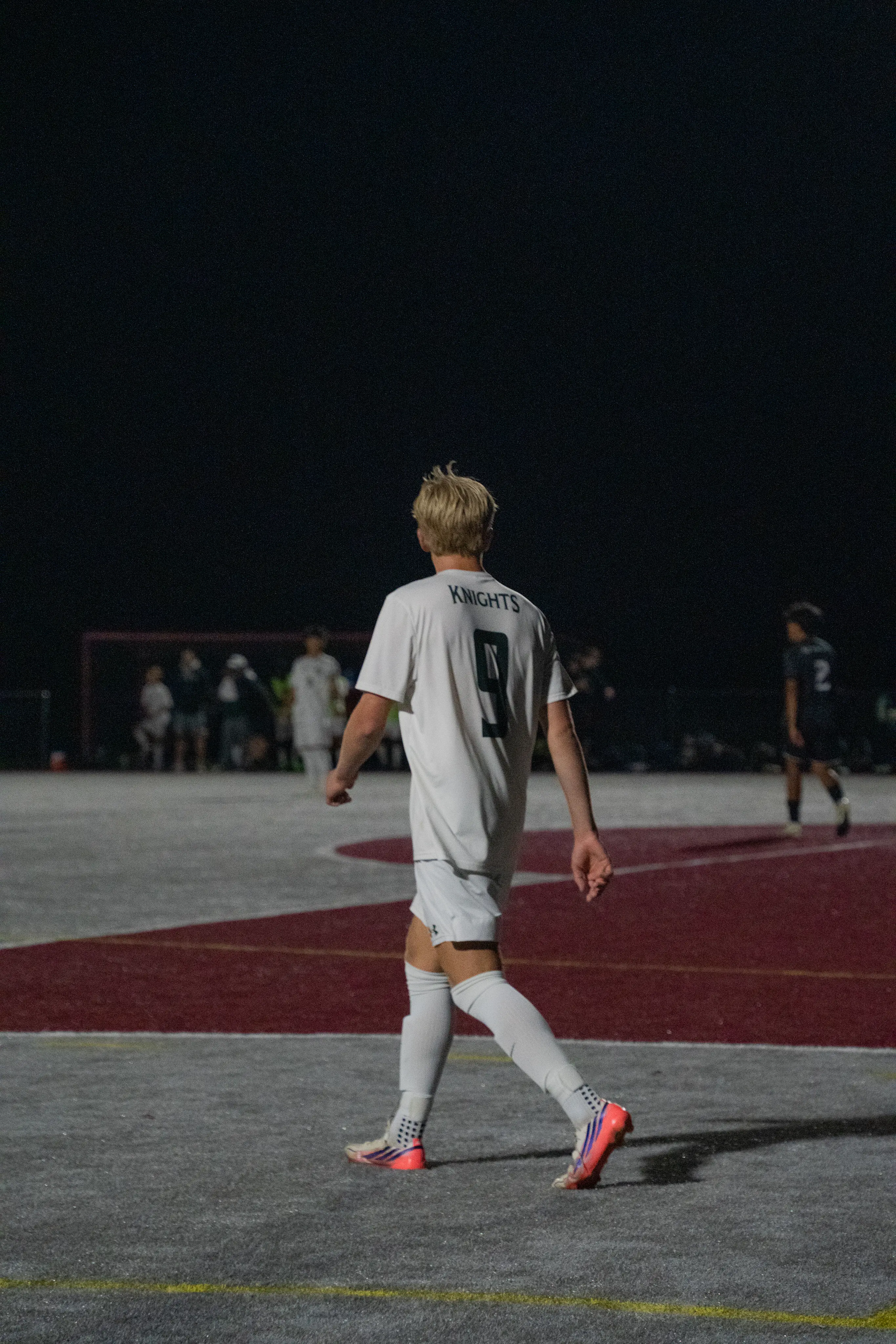 Soccer player number 9 on the field during a night match