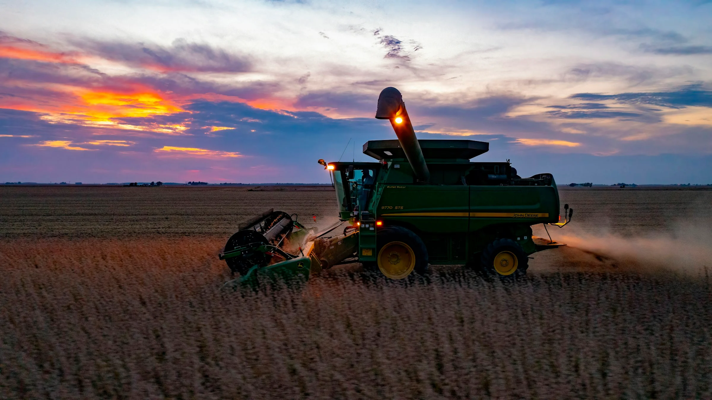 A combine harvesting soybeans at dusk. Contextual photograph, not a verified AgSouth location or customer.