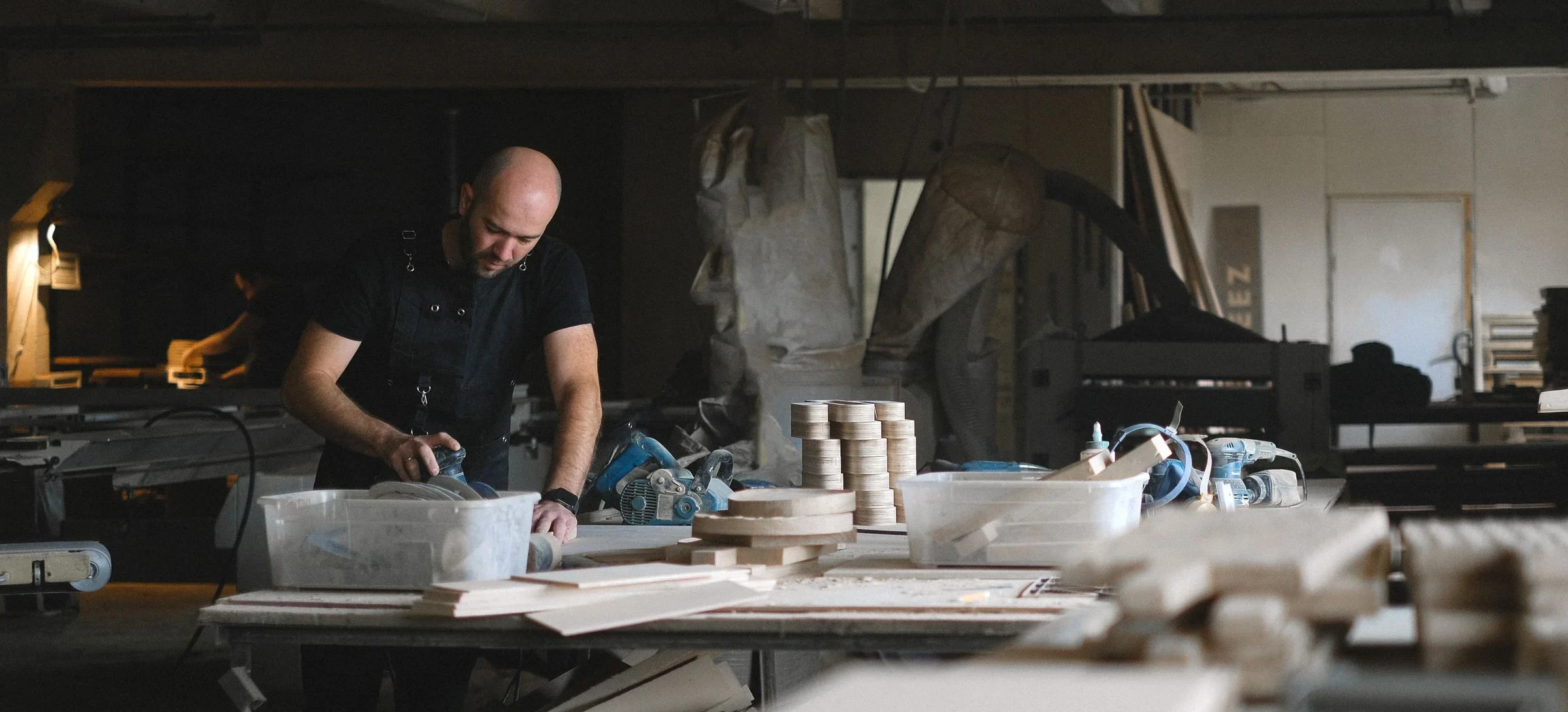 Stock photo of a craftsman sanding wood at a carpentry workbench