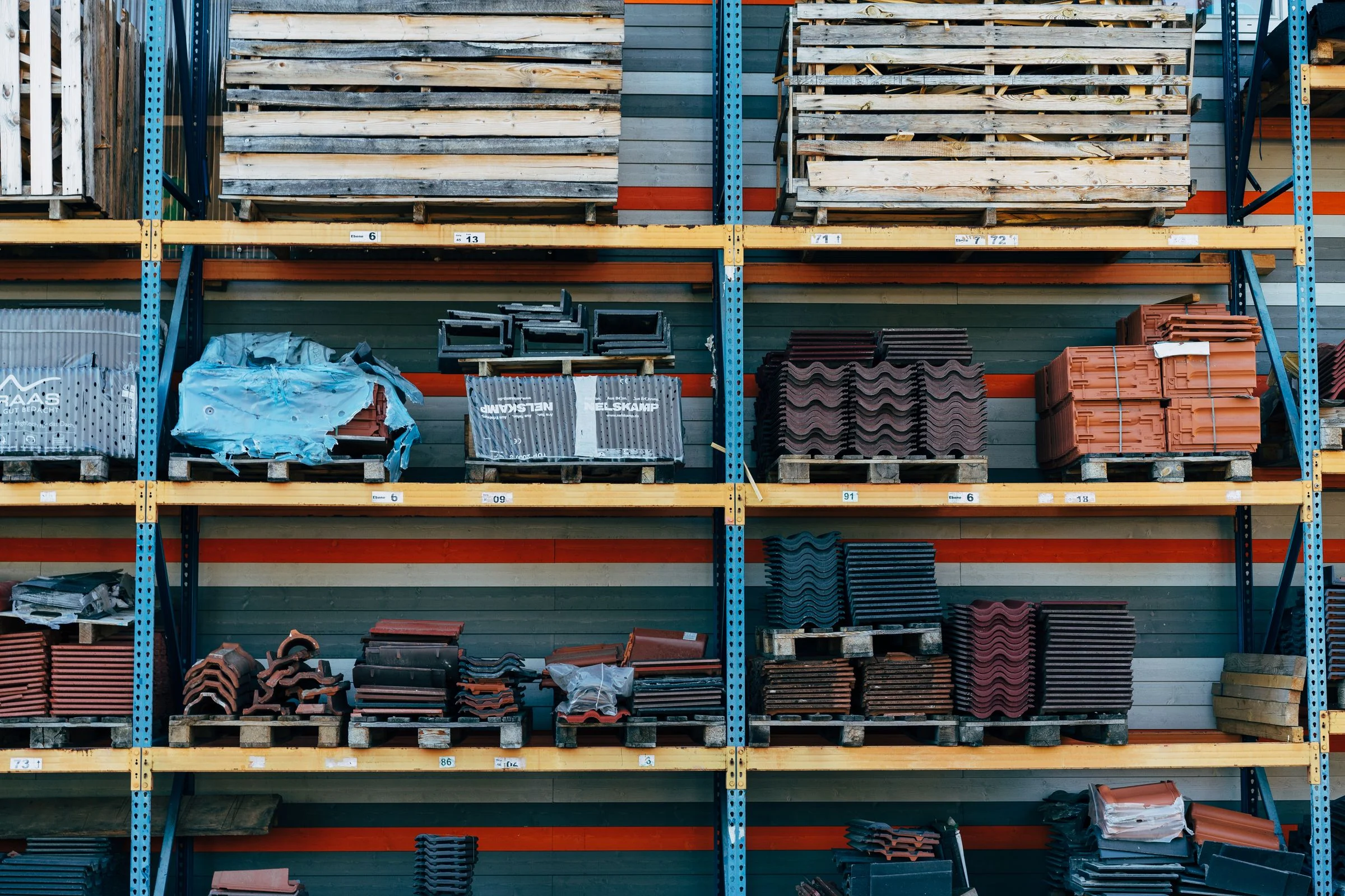 Stock photo of building-material storage racks holding roofing tiles and pallets
