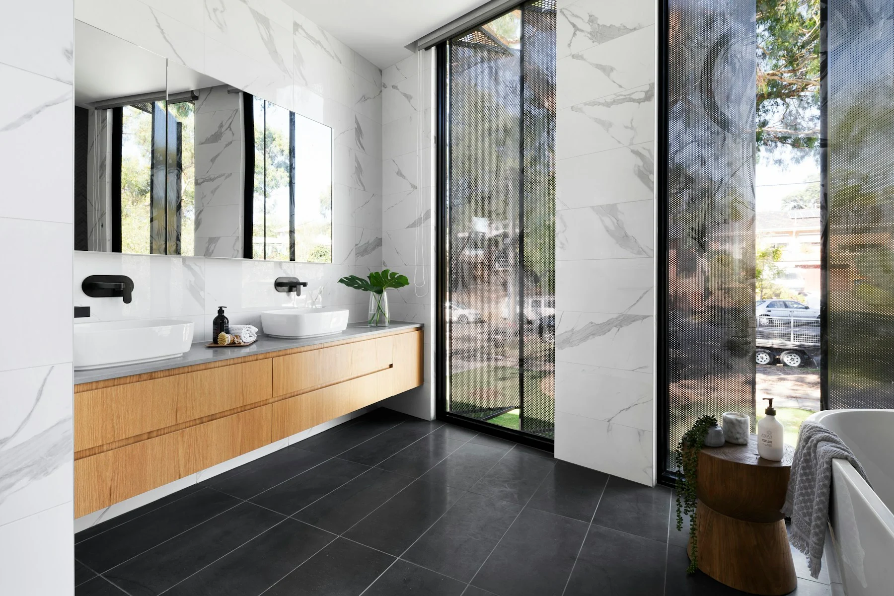 Representative spa bathroom with marble, wood millwork, and natural light