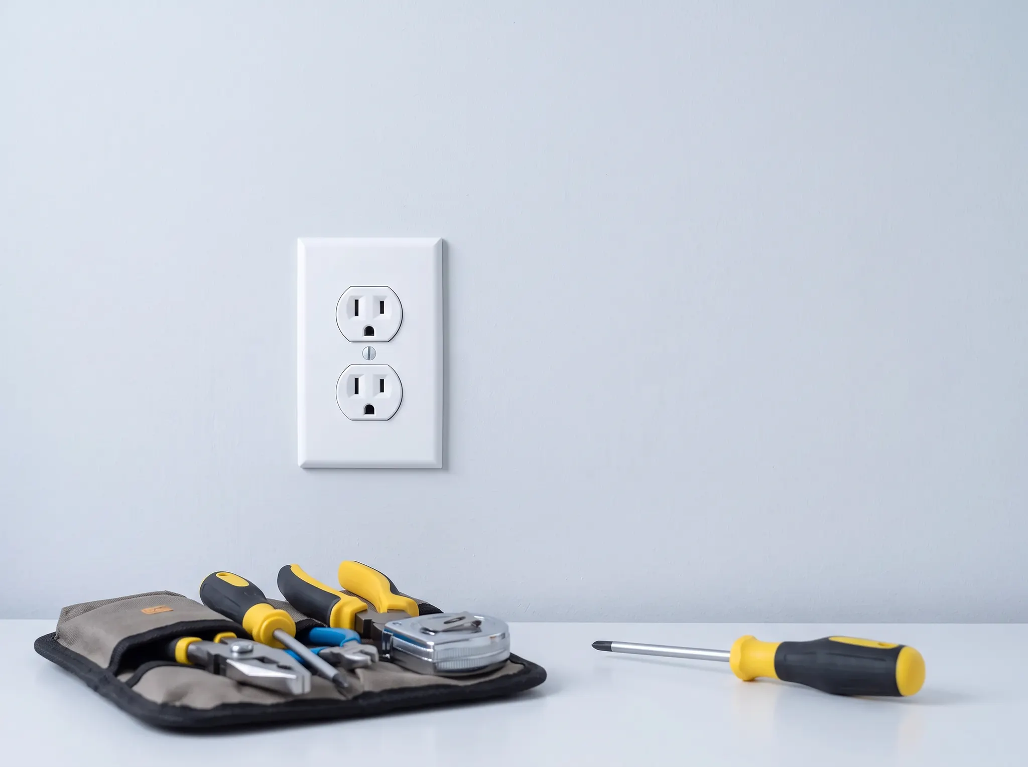 AI-generated illustration of a finished electrical outlet repair with neatly arranged tools