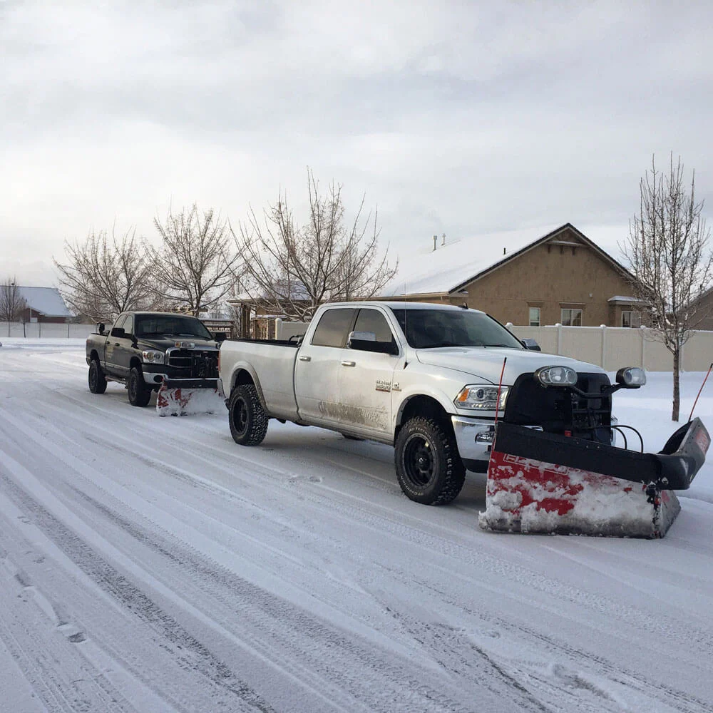 Greenscapes plow trucks clearing a snowy lot