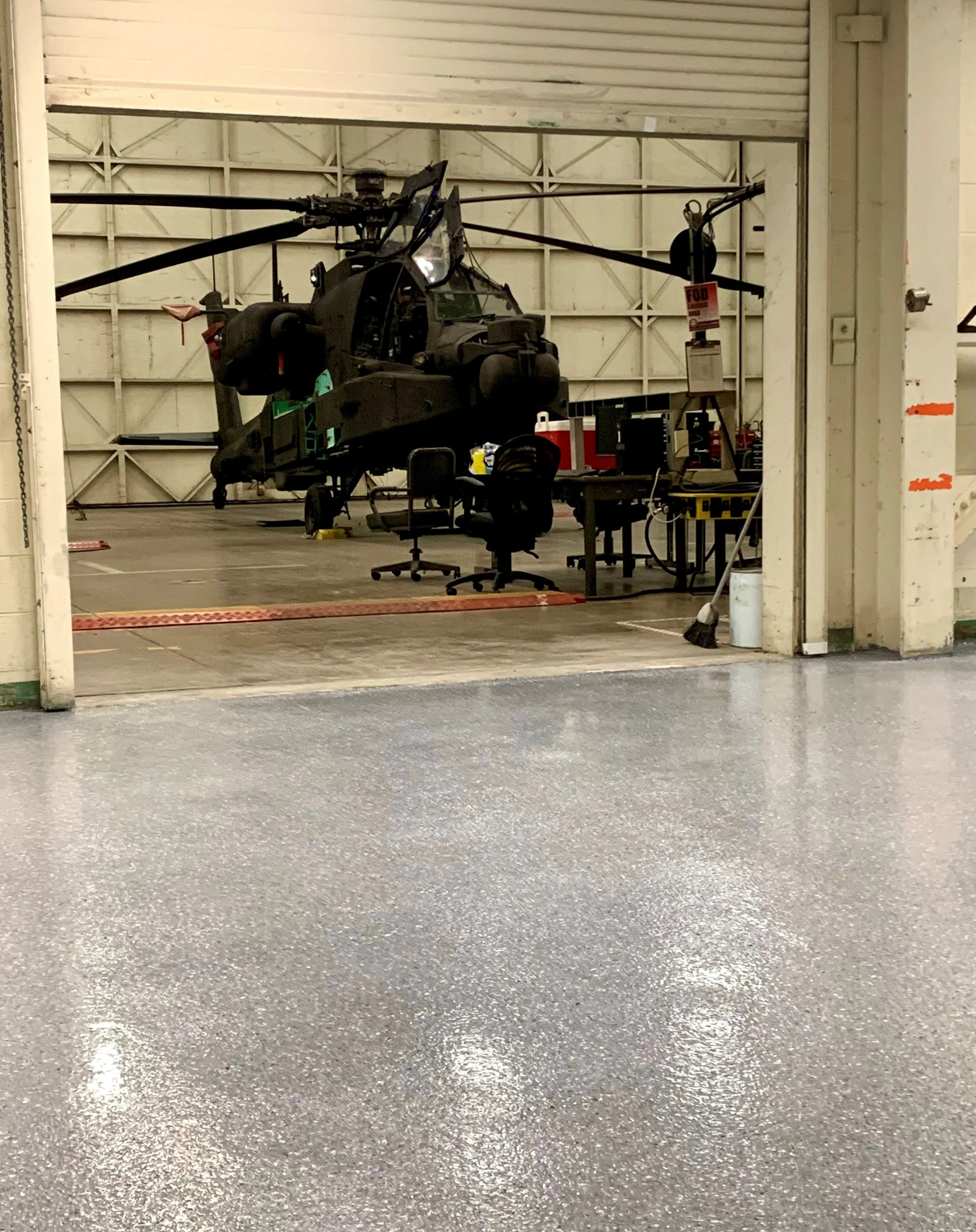Maintenance hangar with a coated floor and military helicopter