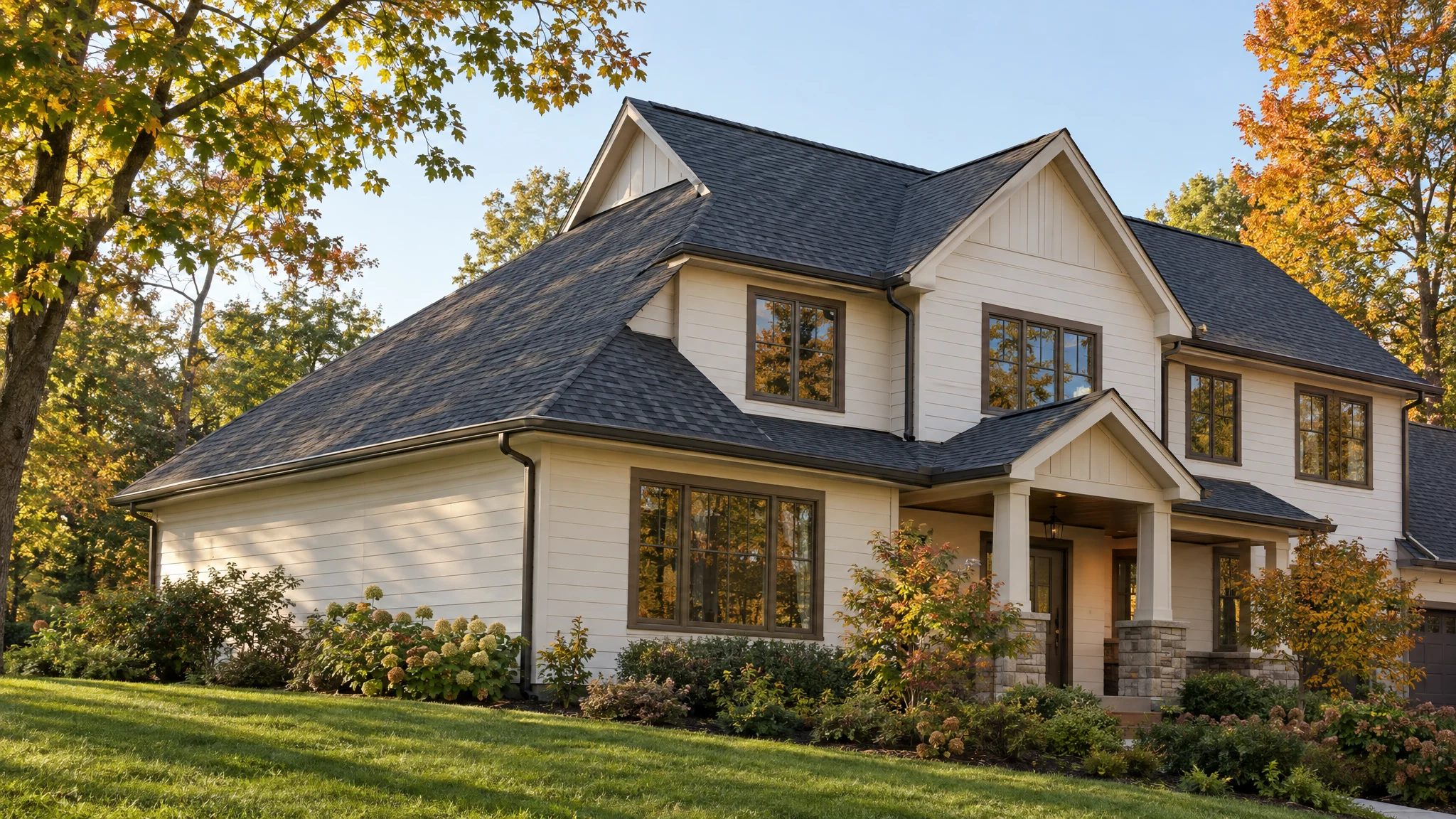 Illustrative two-story home with a new charcoal shingle roof among autumn trees; not a completed Three Strands project