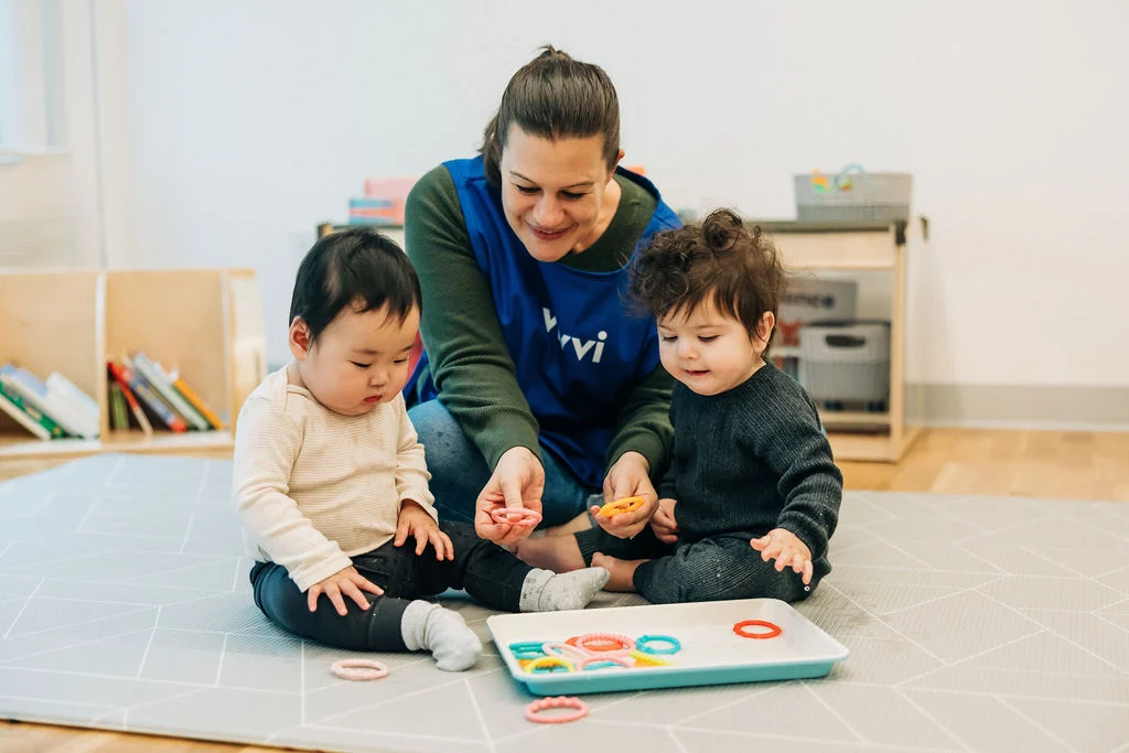 A Vivvi caregiver playing with two young children