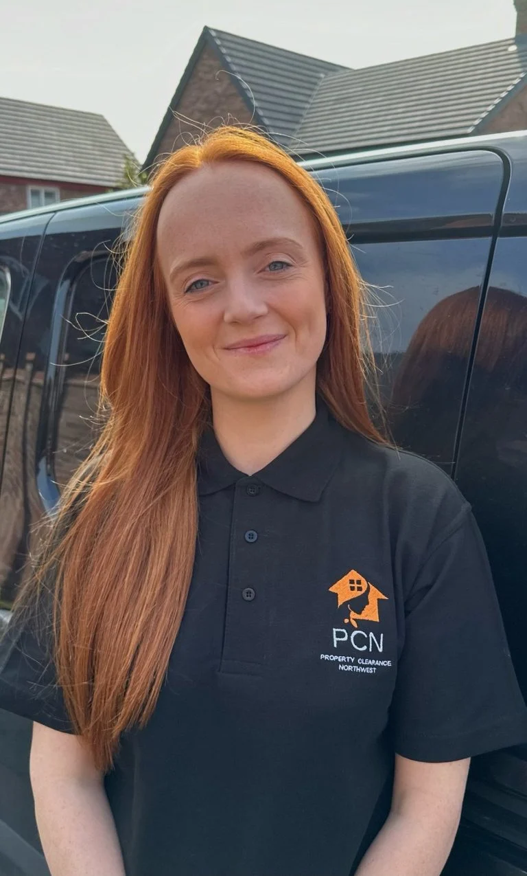 A member of the female-led Property Clearance North West team wearing the company polo shirt