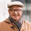 Smiling man wearing glasses and a cap