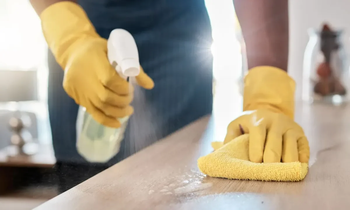 Cleaner wiping a surface with a yellow cloth