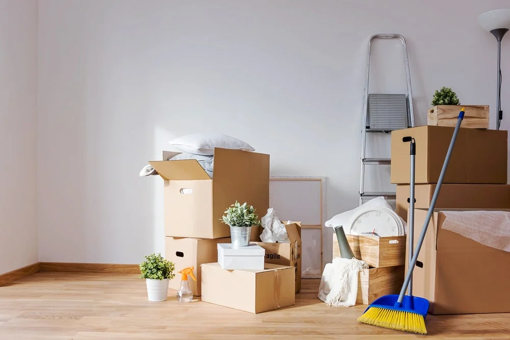Moving boxes and cleaning supplies in an empty room