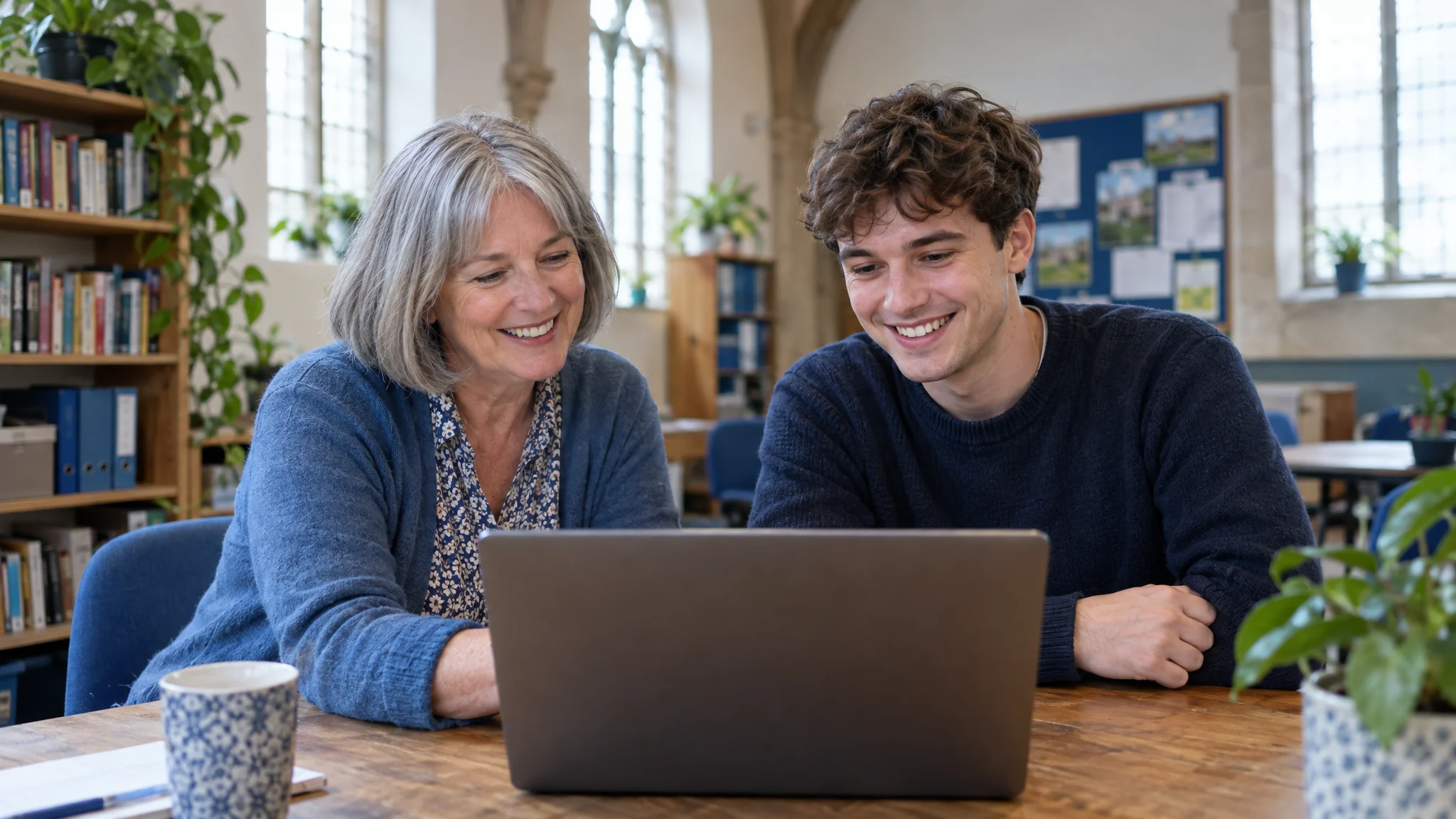 Two charity staff updating their website together on a laptop