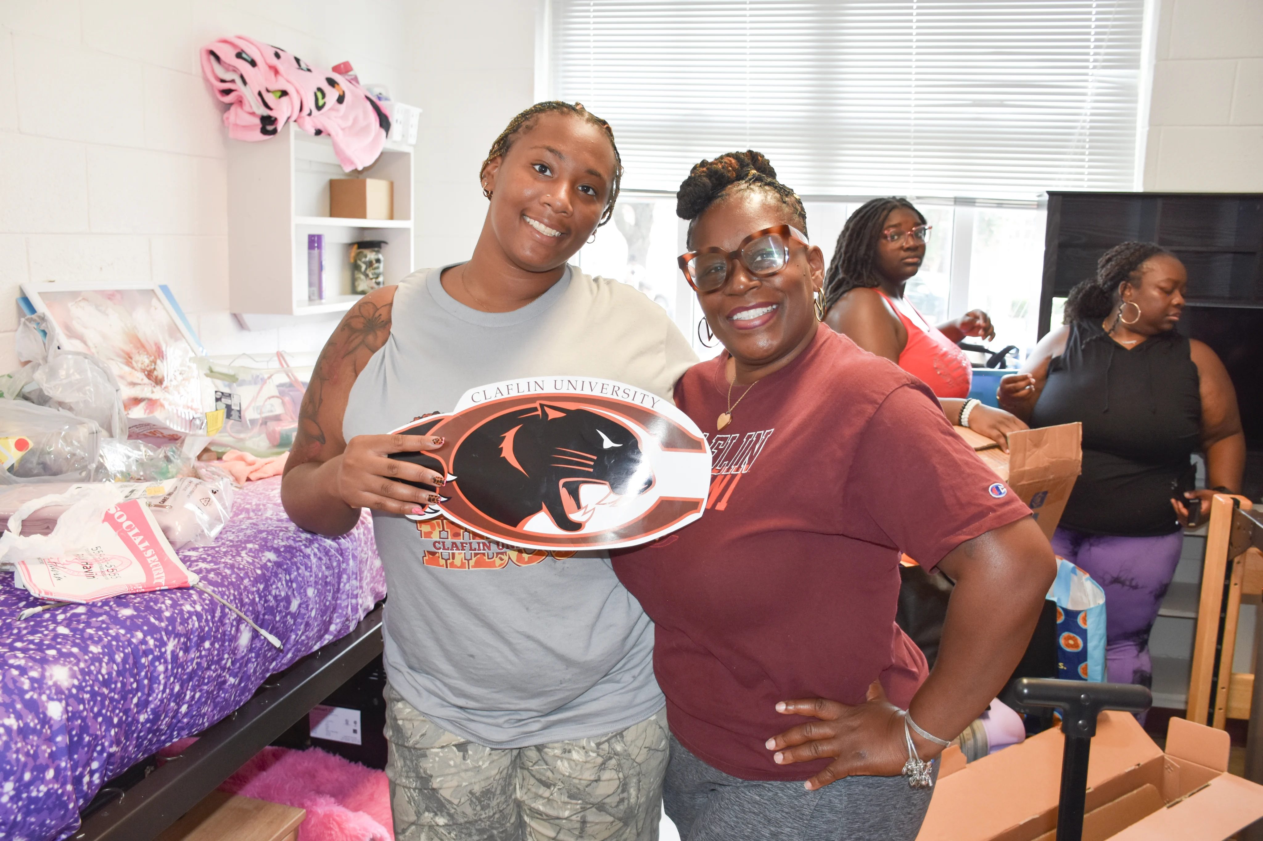A new Claflin student and family member smiling together in a residence hall