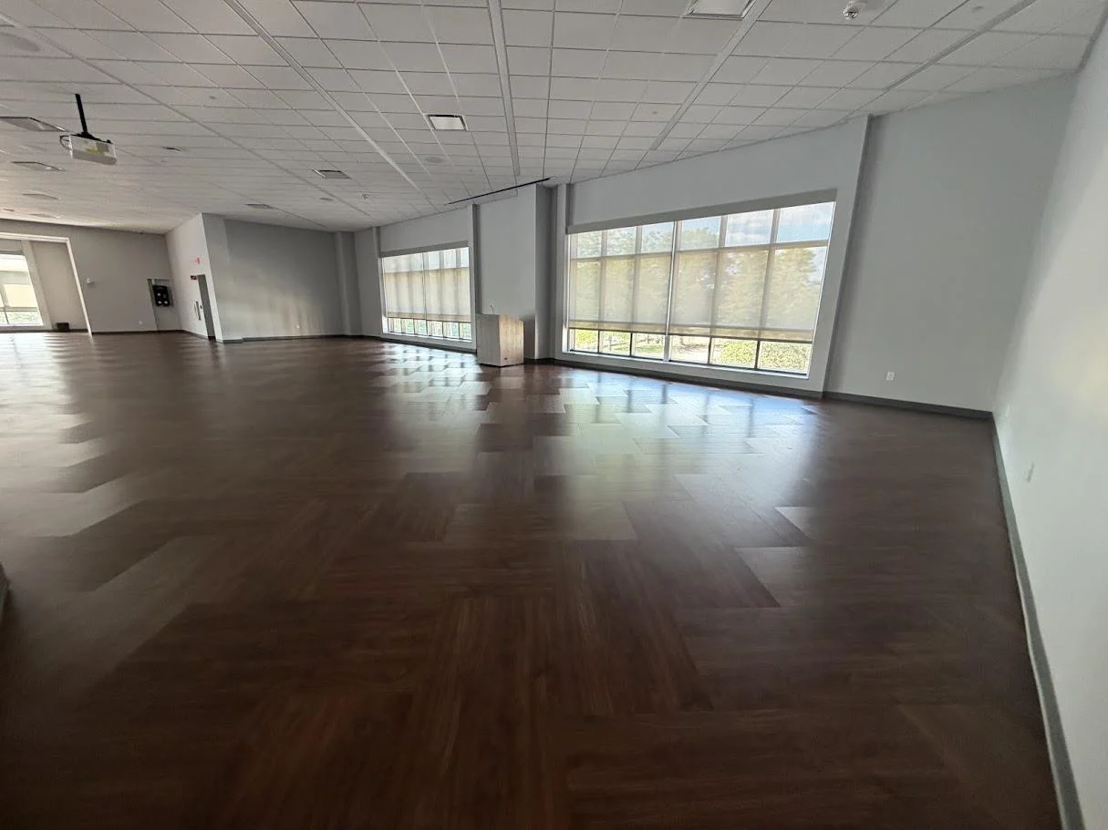 Ballroom C with dark wood floors and large windows with blinds