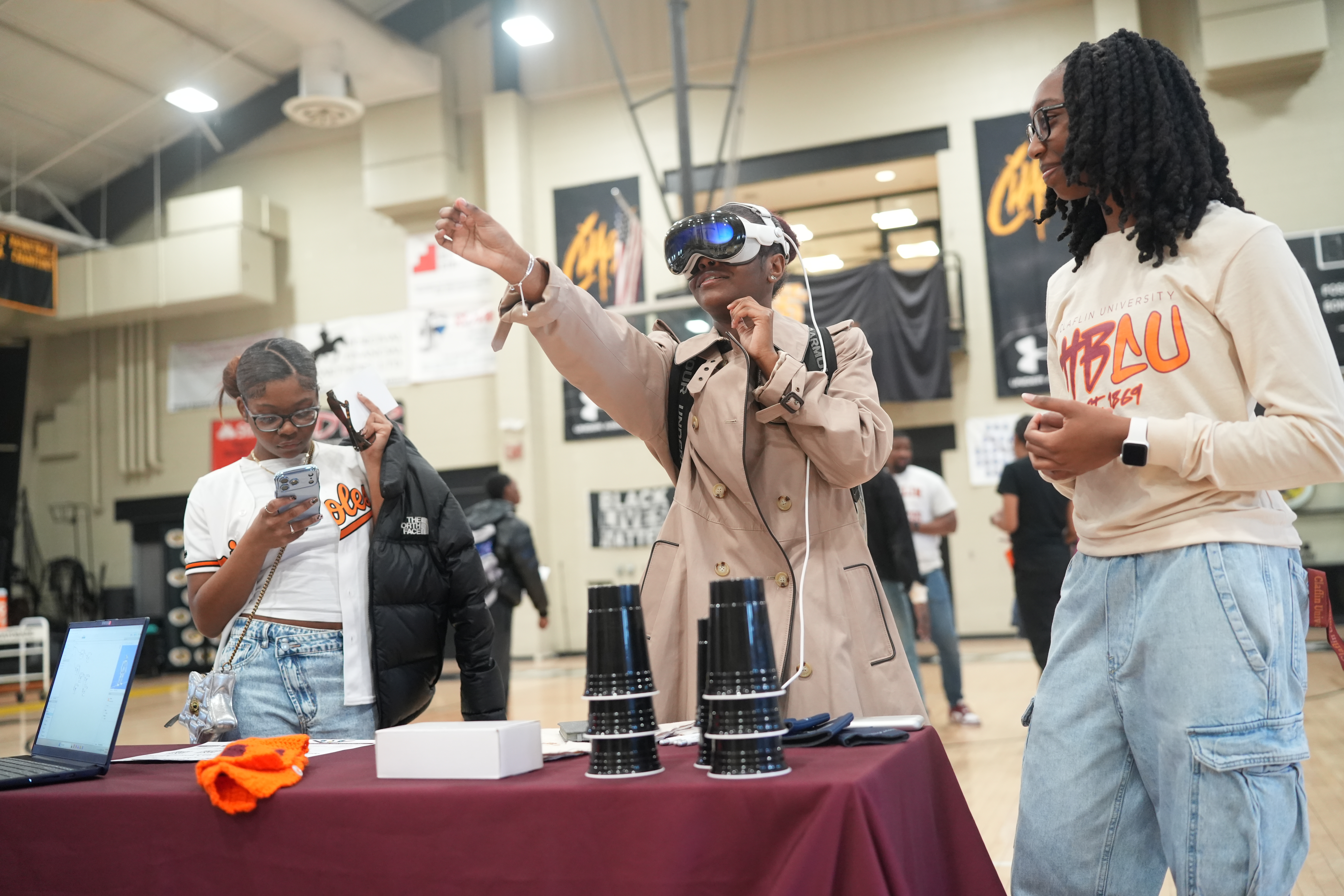 A student tries a mixed-reality headset while classmates look on at a Claflin event