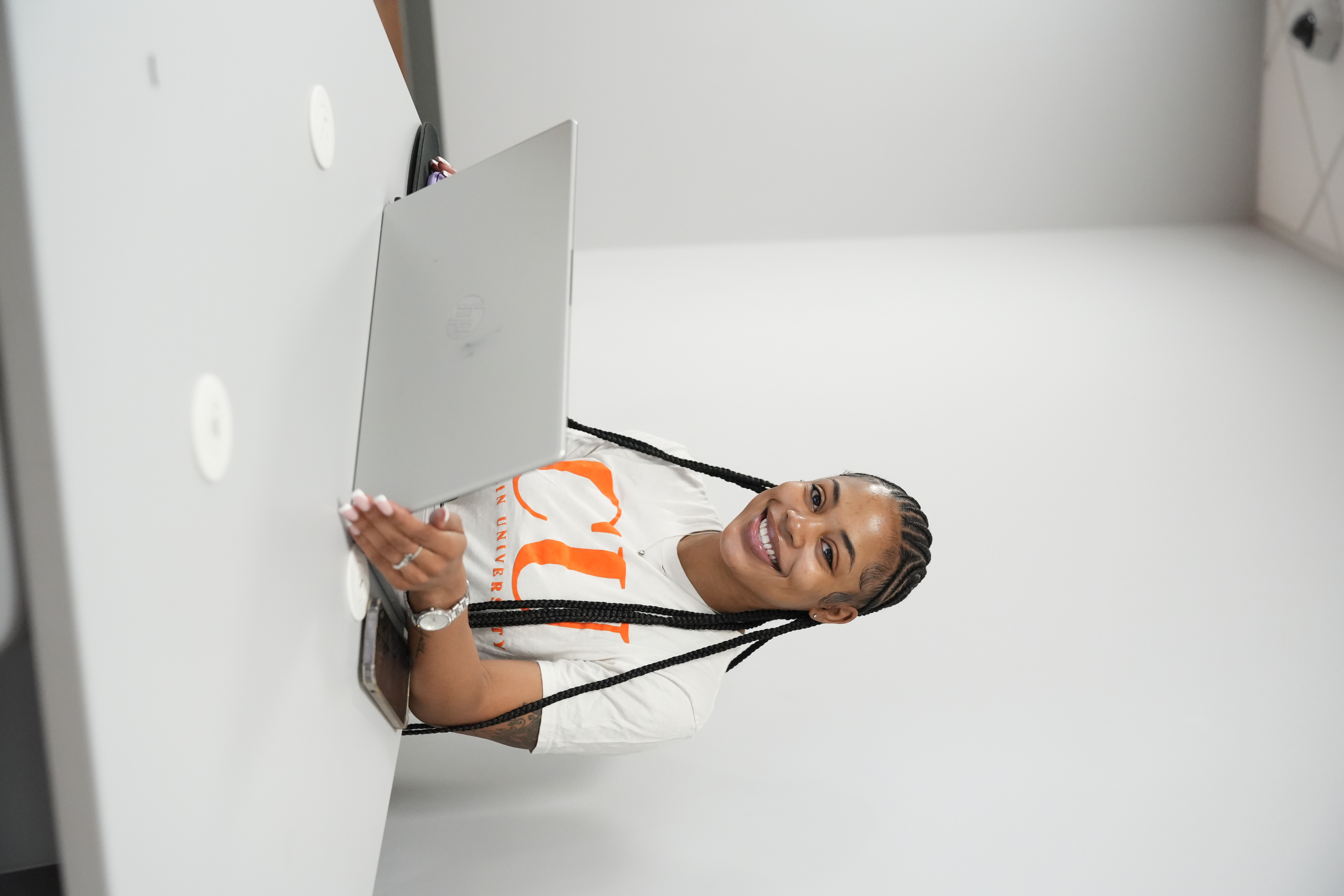 A Claflin student smiling while working at her laptop