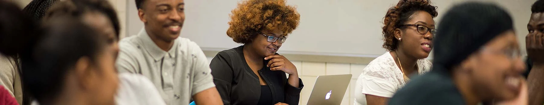 Claflin students smiling and taking notes during a class discussion