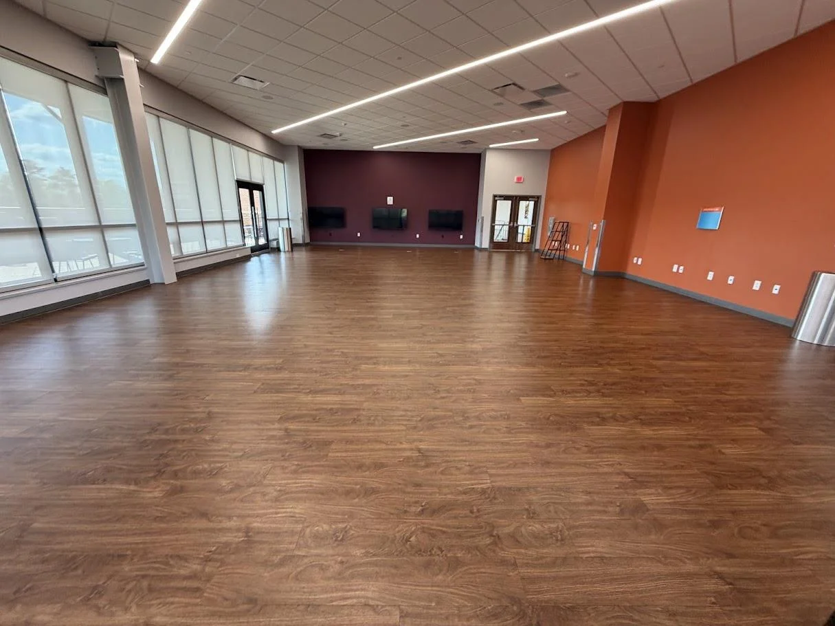 Third-floor lounge with wood floors and orange and purple accent walls