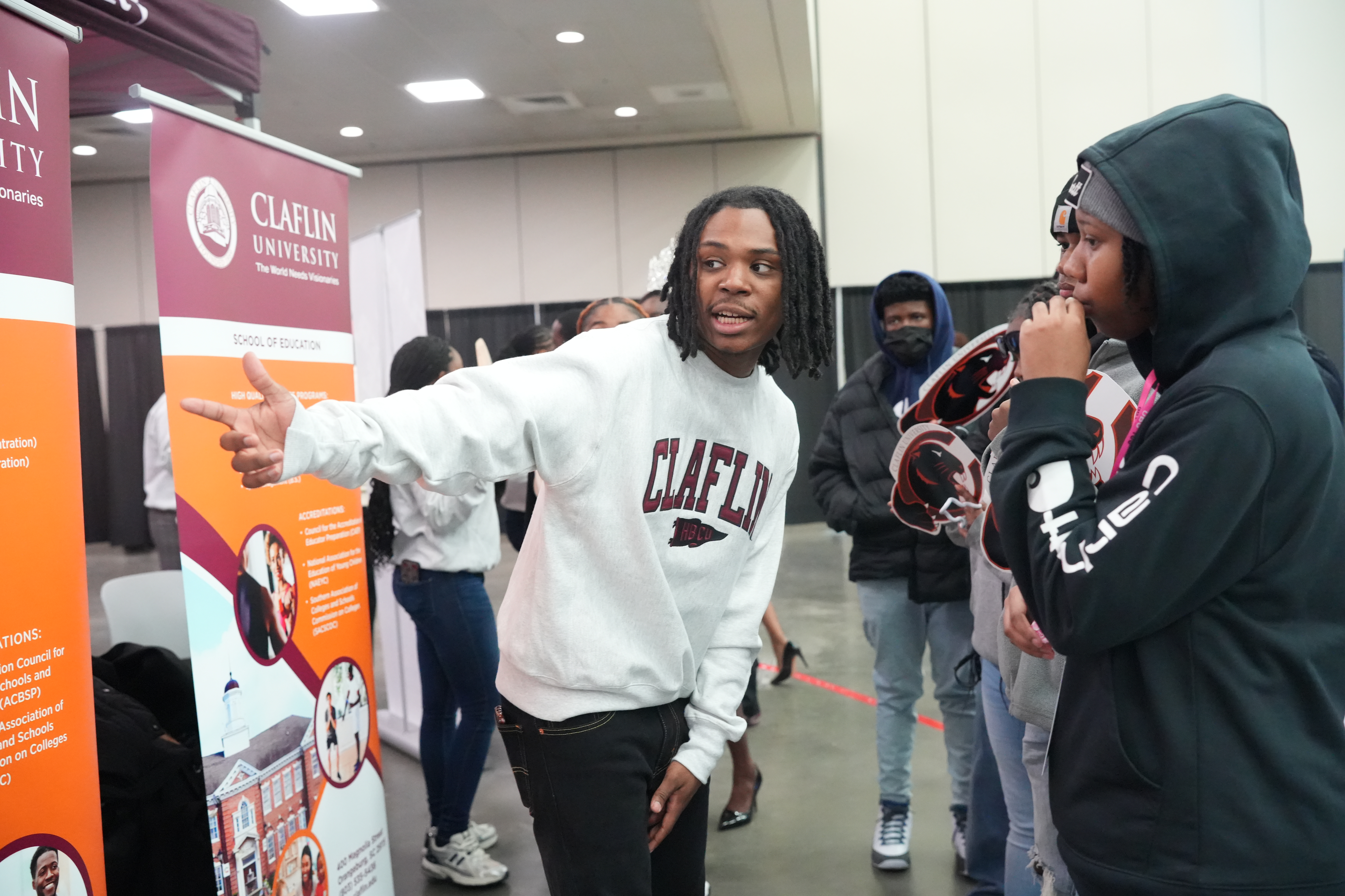 A Claflin student guides visitors through university information at a community event
