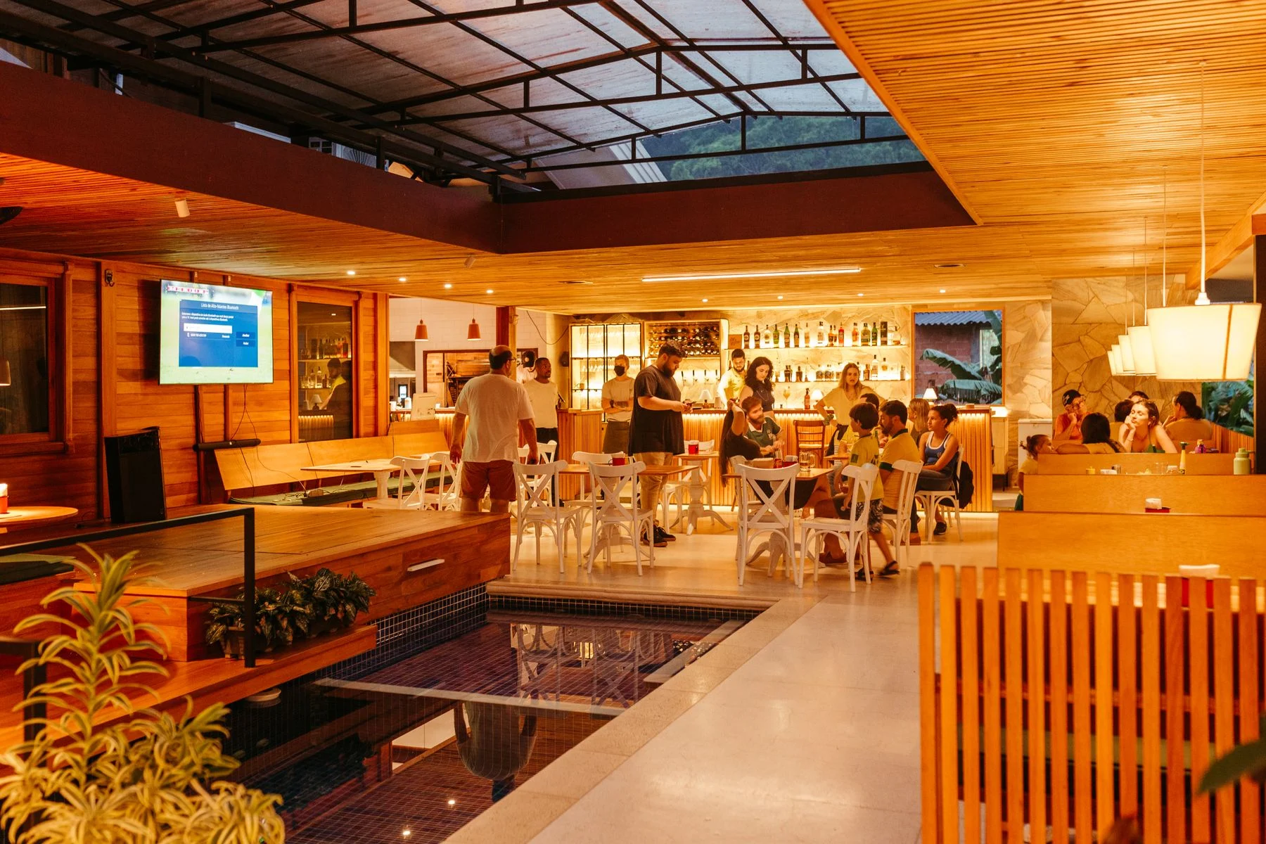 A busy restaurant bar with patrons in warm evening light