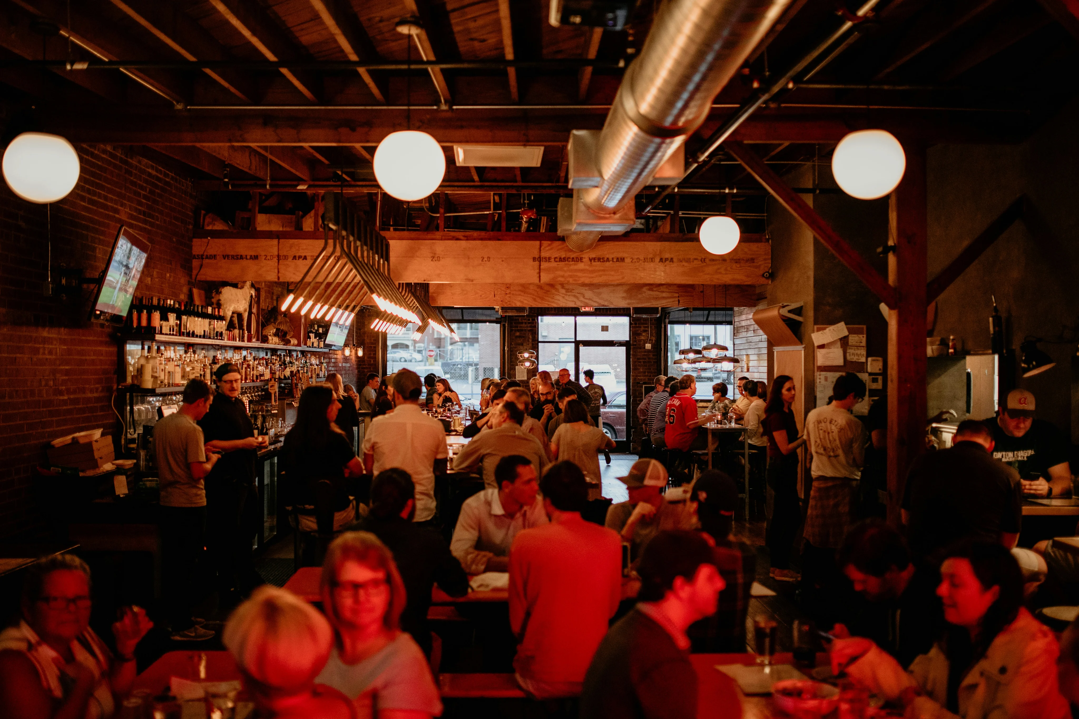 A lively restaurant dining room full of guests eating and drinking